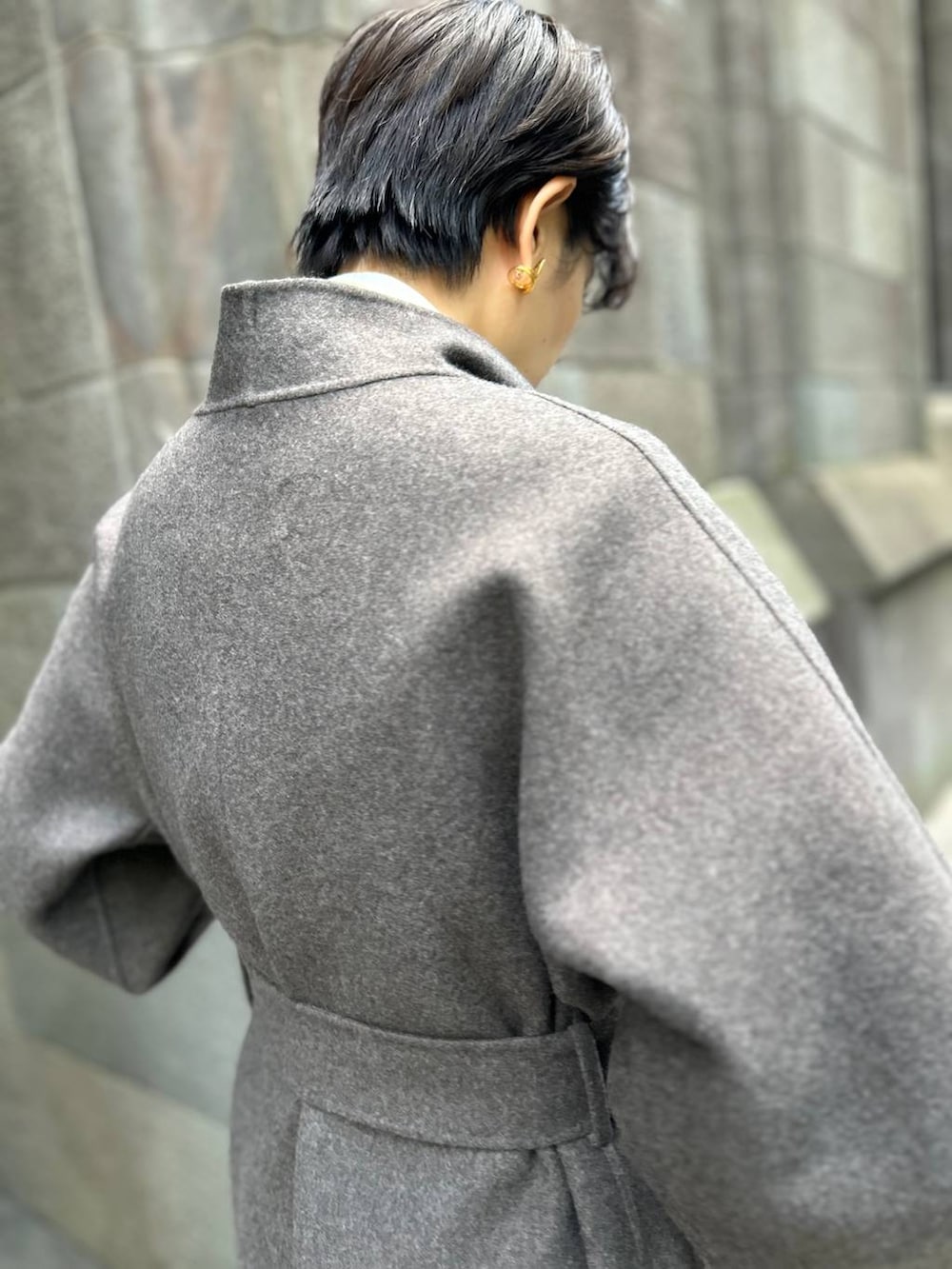 ブラウン系のノーカラーコート、ホワイト系のスラックス、ホワイト系のシャツ/ブラウスを着用したレディースの秋コーディネートの8枚目の写真