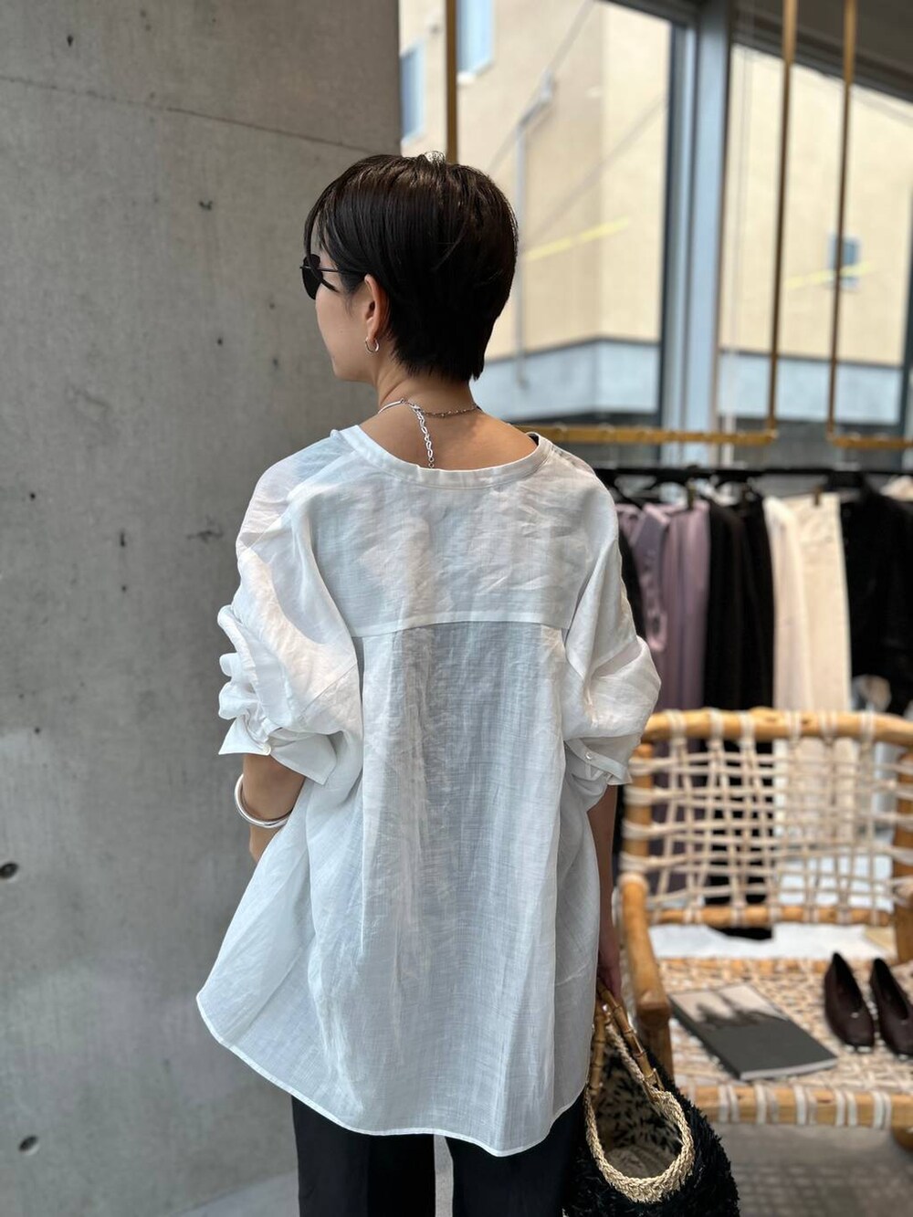 ブラック系のタンクトップ、ブラック系のかごバッグ、ブラック系のスラックスを着用したレディースの夏コーディネートの7枚目の写真