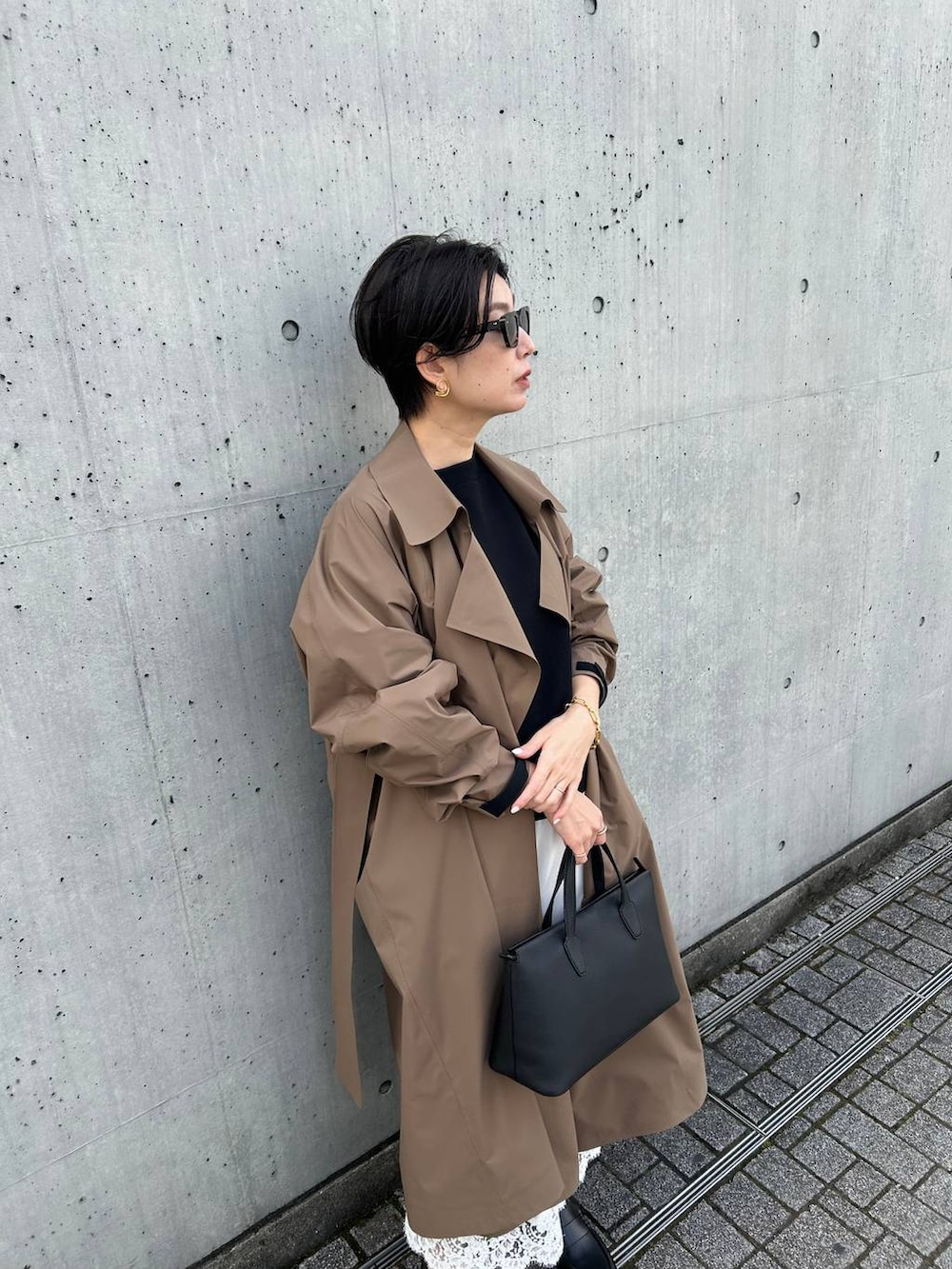 ブラック系のニット/セーター、ベージュ系のトレンチコートを着用したレディースの冬コーディネートの5枚目の写真