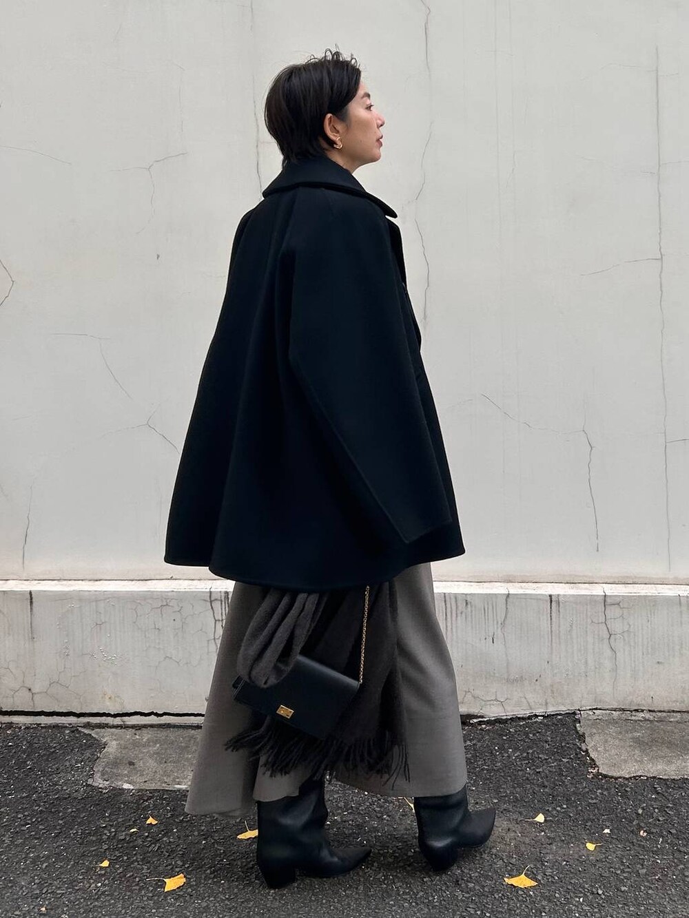 ブラック系のニット/セーター、ベージュ系のスカート、ブラウン系のストール/ショールを着用したレディースの冬コーディネートの7枚目の写真