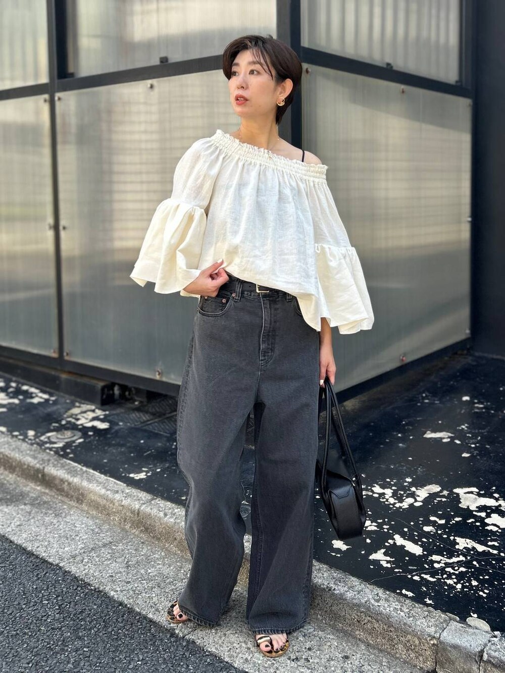 ブラック系のチューブトップ、ホワイト系のシャツ/ブラウス、ブラック系のデニムパンツを着用したレディースの春コーディネートの2枚目の写真