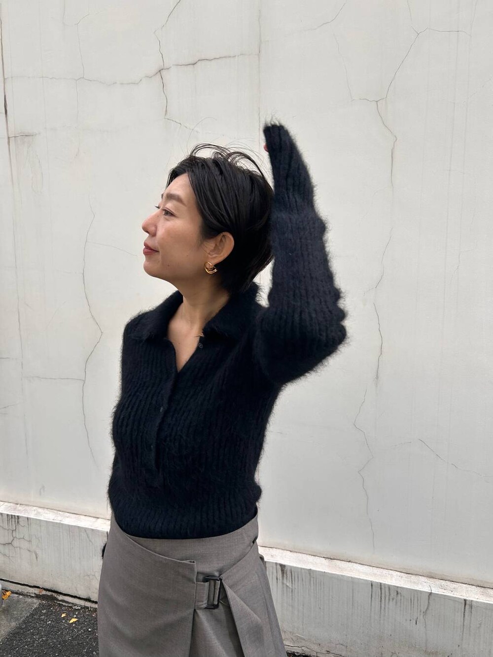 ブラック系のニット/セーター、ベージュ系のスカート、ブラウン系のストール/ショールを着用したレディースの冬コーディネートの4枚目の写真