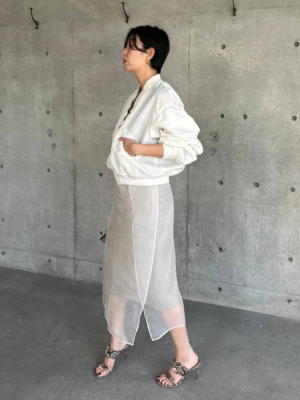 ベージュ系のスカート、ホワイト系のMA-1を着用したレディースの春コーディネートの3枚目の写真