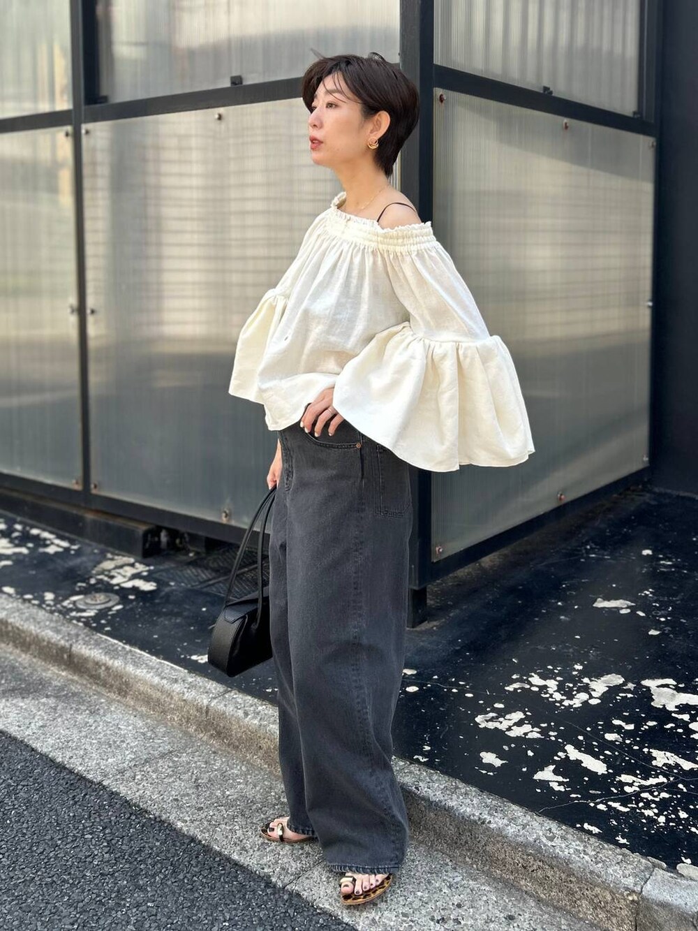 ブラック系のチューブトップ、ホワイト系のシャツ/ブラウス、ブラック系のデニムパンツを着用したレディースの春コーディネートの3枚目の写真