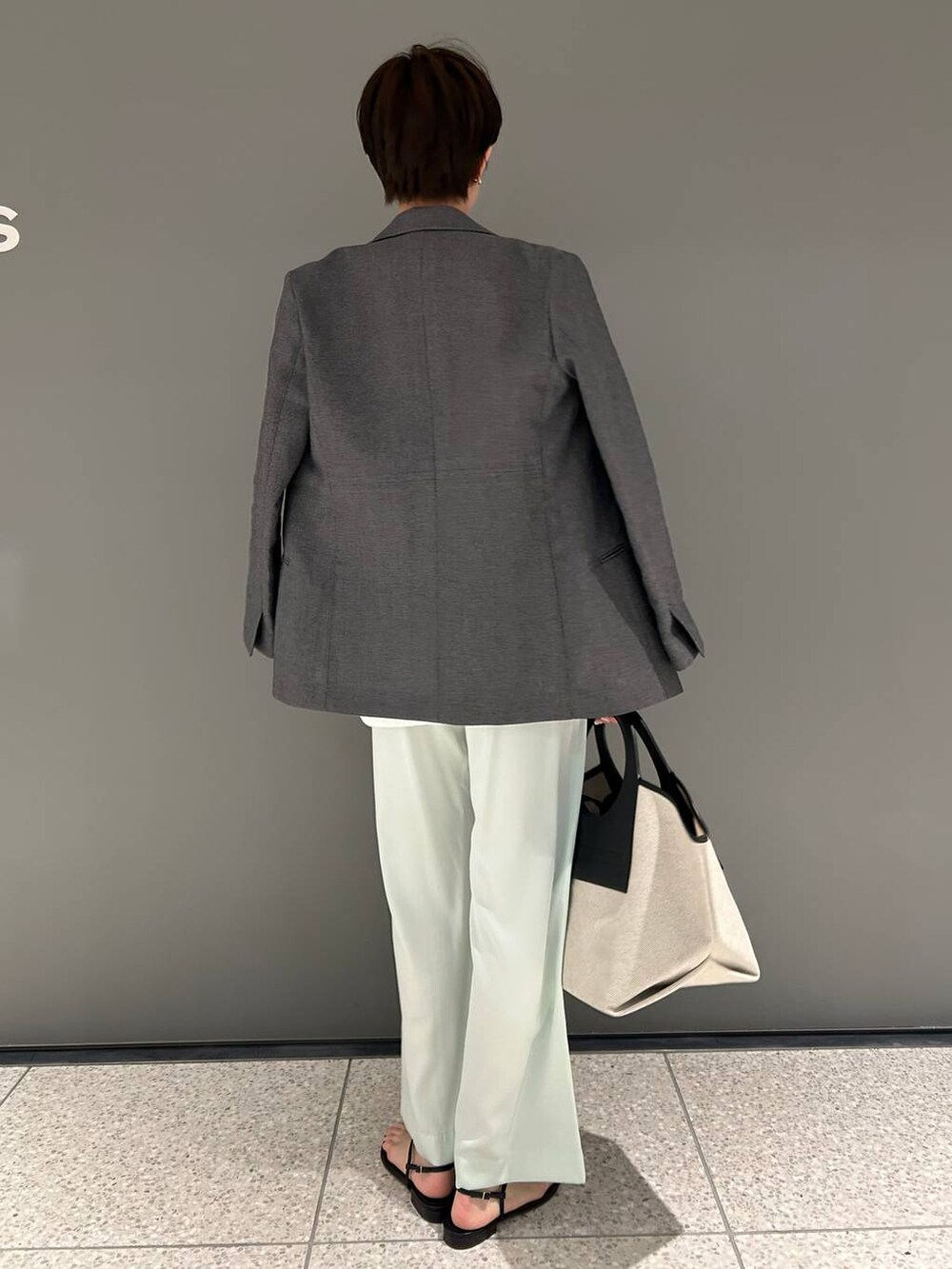 グリーン系のその他パンツ、ホワイト系のニット/セーター、ブラック系のテーラードジャケットを着用したレディースの春コーディネートの5枚目の写真