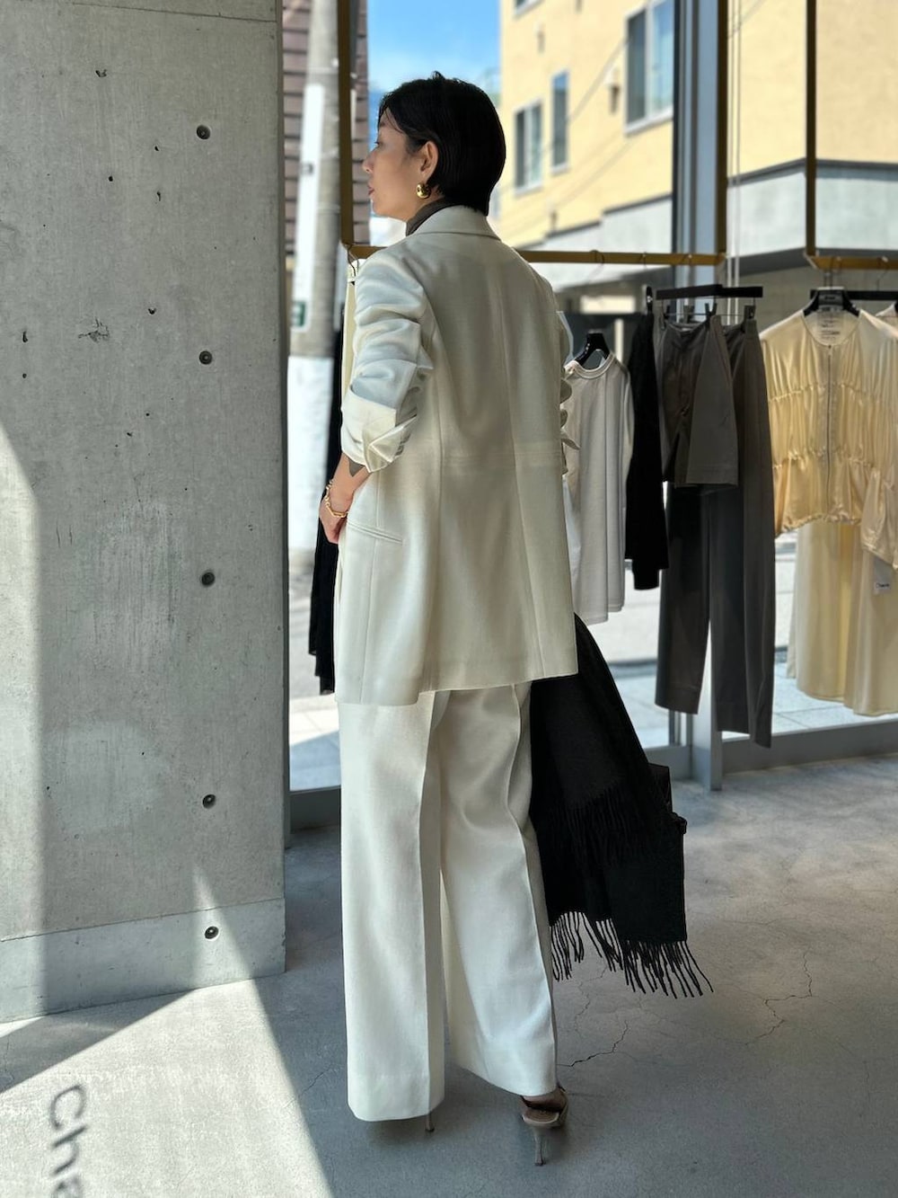 ベージュ系のニット/セーター、ホワイト系のスラックス、ホワイト系のテーラードジャケットを着用したレディースの秋コーディネートの4枚目の写真