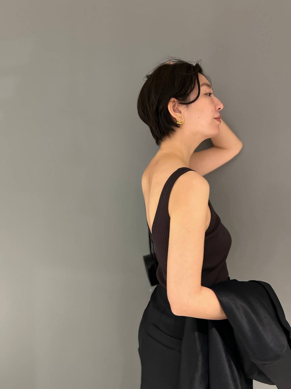 ブラック系のスラックス、ブラック系のテーラードジャケットを着用したレディースの春コーディネートの8枚目の写真