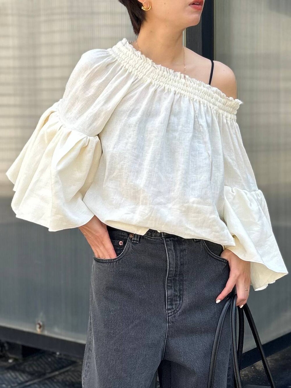 ブラック系のチューブトップ、ホワイト系のシャツ/ブラウス、ブラック系のデニムパンツを着用したレディースの春コーディネートの6枚目の写真