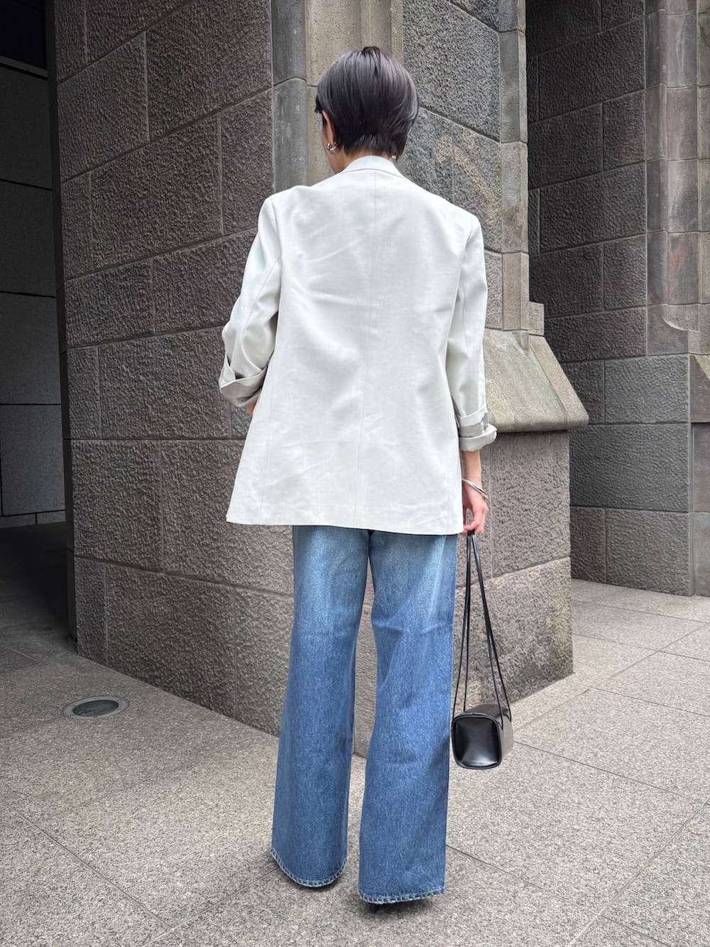 ブルー系のデニムパンツ、ホワイト系のテーラードジャケットを着用したレディースの冬コーディネートの4枚目の写真