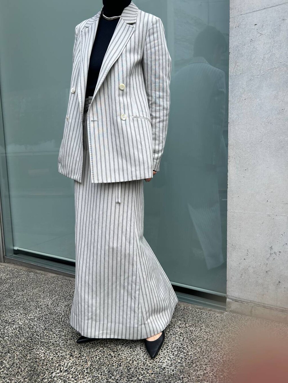 ブルー系のニット/セーター、ホワイト系のテーラードジャケット、ホワイト系のスカートを着用したレディースの冬コーディネートの8枚目の写真