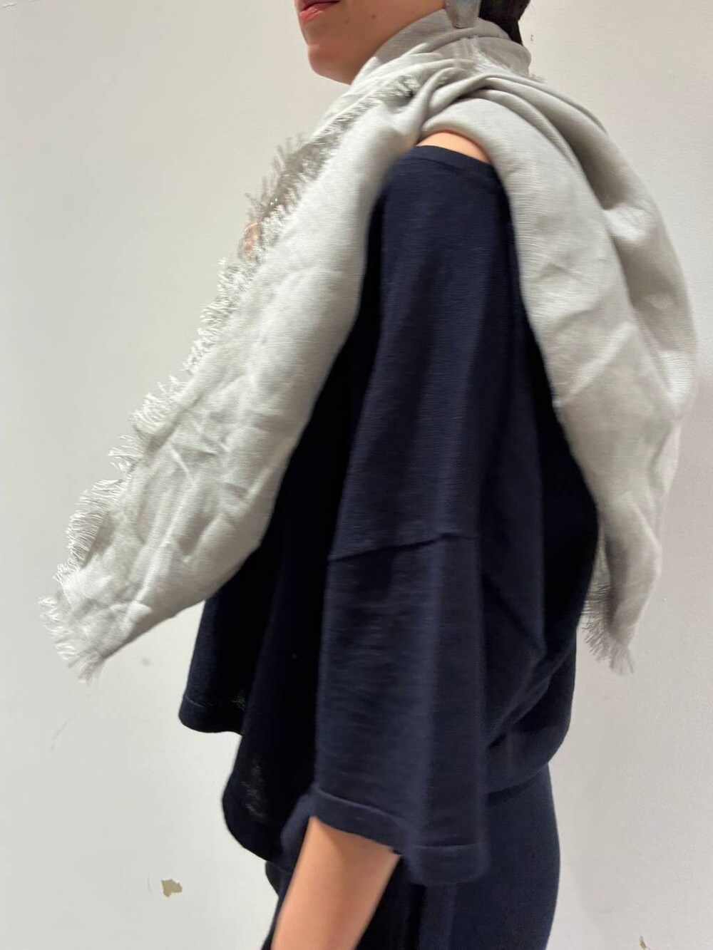 ブルー系のニット/セーター、ブルー系のスカート、グレー系のストール/ショールを着用したレディースの春コーディネートの6枚目の写真