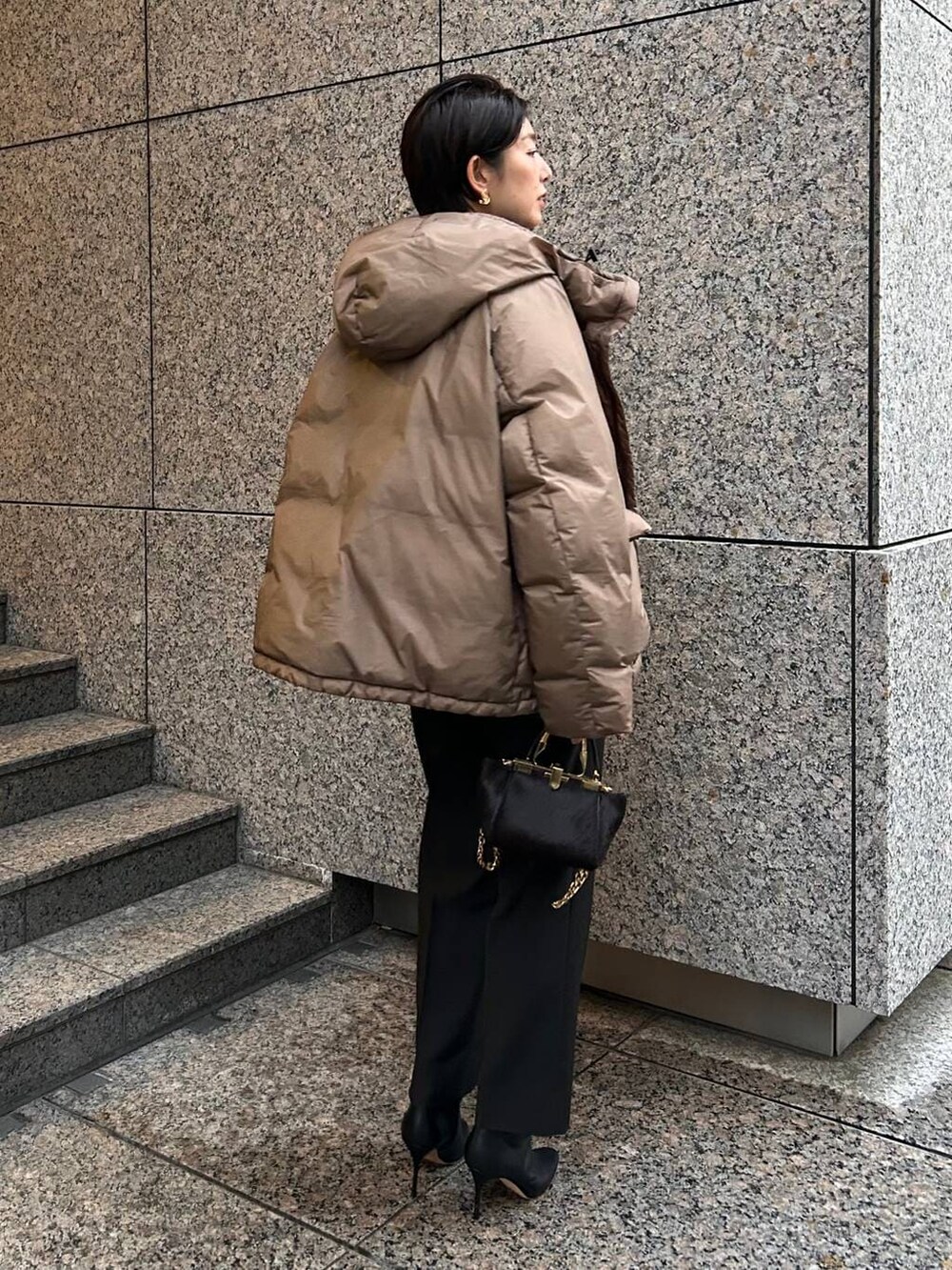 ベージュ系のニット/セーター、ブラウン系のダウンジャケット/コート、ブラック系のスラックスを着用したレディースの冬コーディネートの5枚目の写真