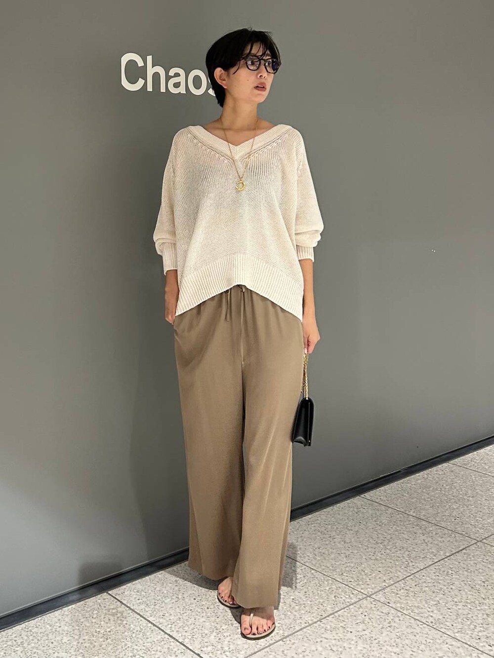 ベージュ系のその他パンツ、ホワイト系のニット/セーターを着用したレディースの夏コーディネートの2枚目の写真