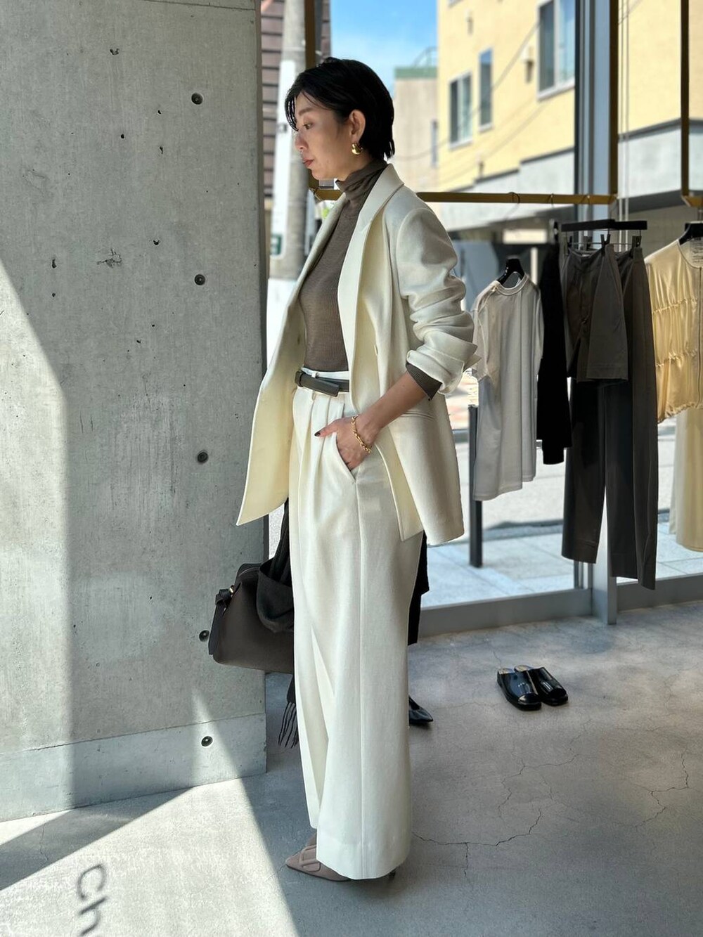 ベージュ系のニット/セーター、ホワイト系のスラックス、ホワイト系のテーラードジャケットを着用したレディースの秋コーディネートの3枚目の写真