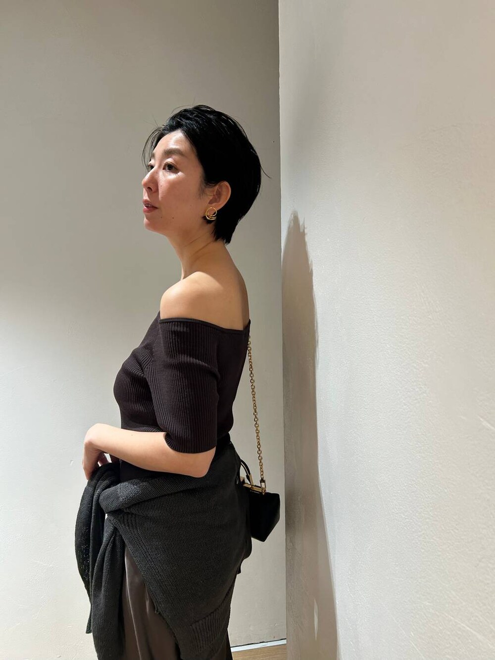 グリーン系のカーディガン/ボレロ、グリーン系のスカート、ブラウン系のTシャツ/カットソーを着用したレディースの春コーディネートの8枚目の写真