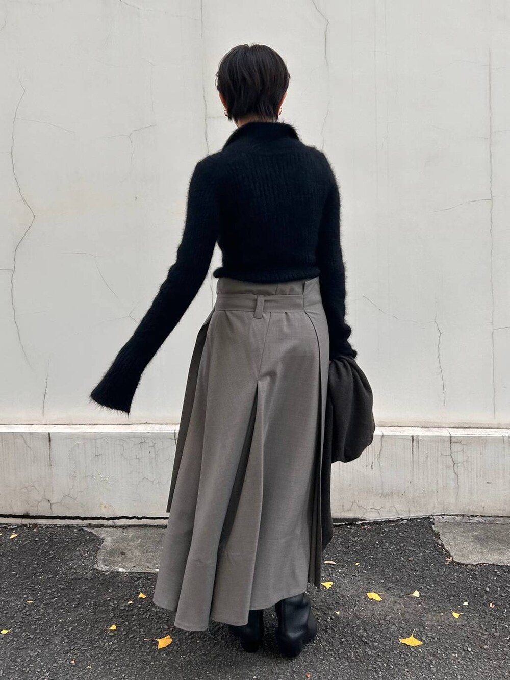 ブラック系のニット/セーター、ベージュ系のスカート、ブラウン系のストール/ショールを着用したレディースの冬コーディネートの3枚目の写真