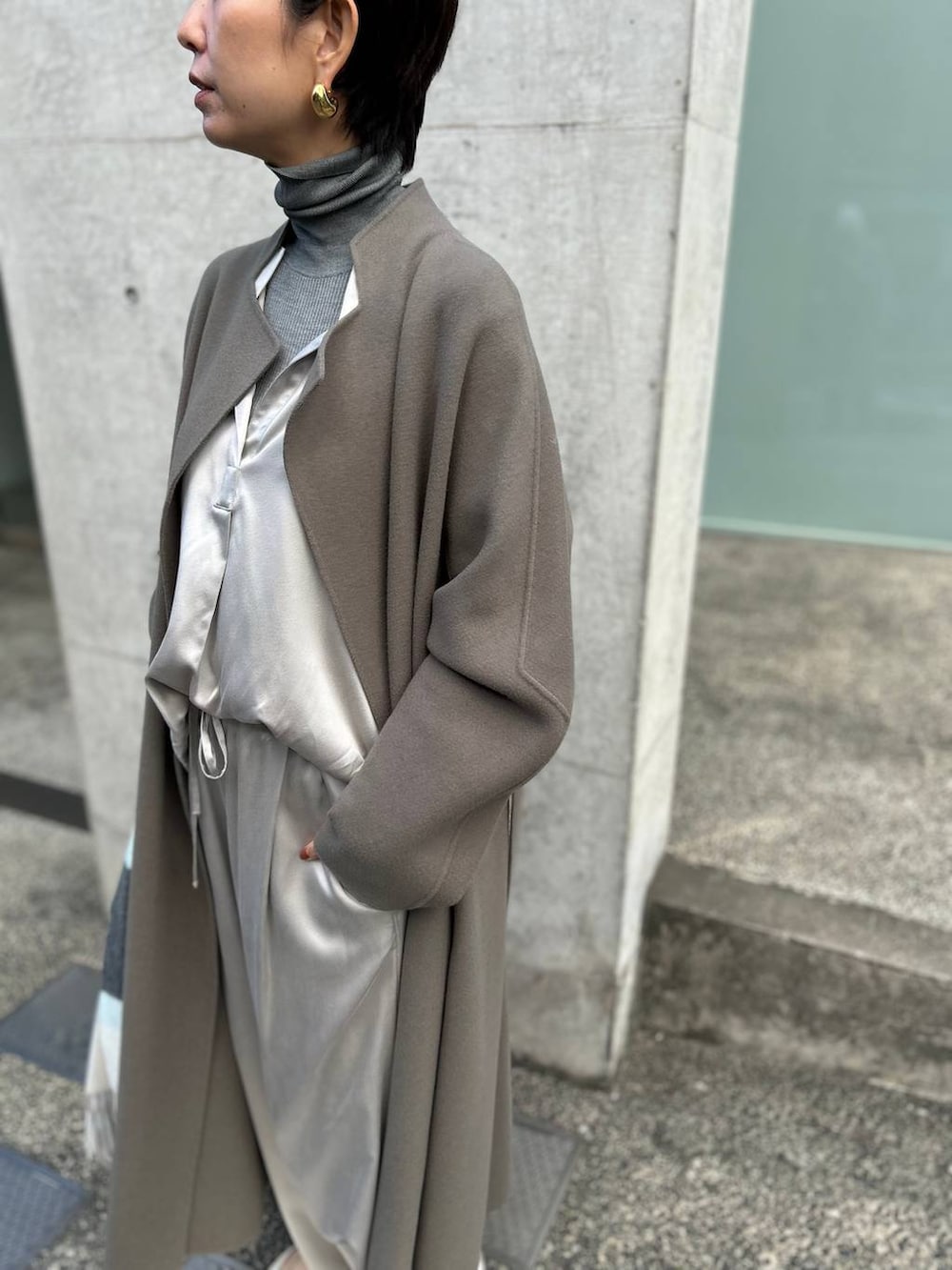 グレー系のその他パンツ、グレー系のニット/セーター、ブラウン系のノーカラーコートを着用したレディースの秋コーディネートの5枚目の写真