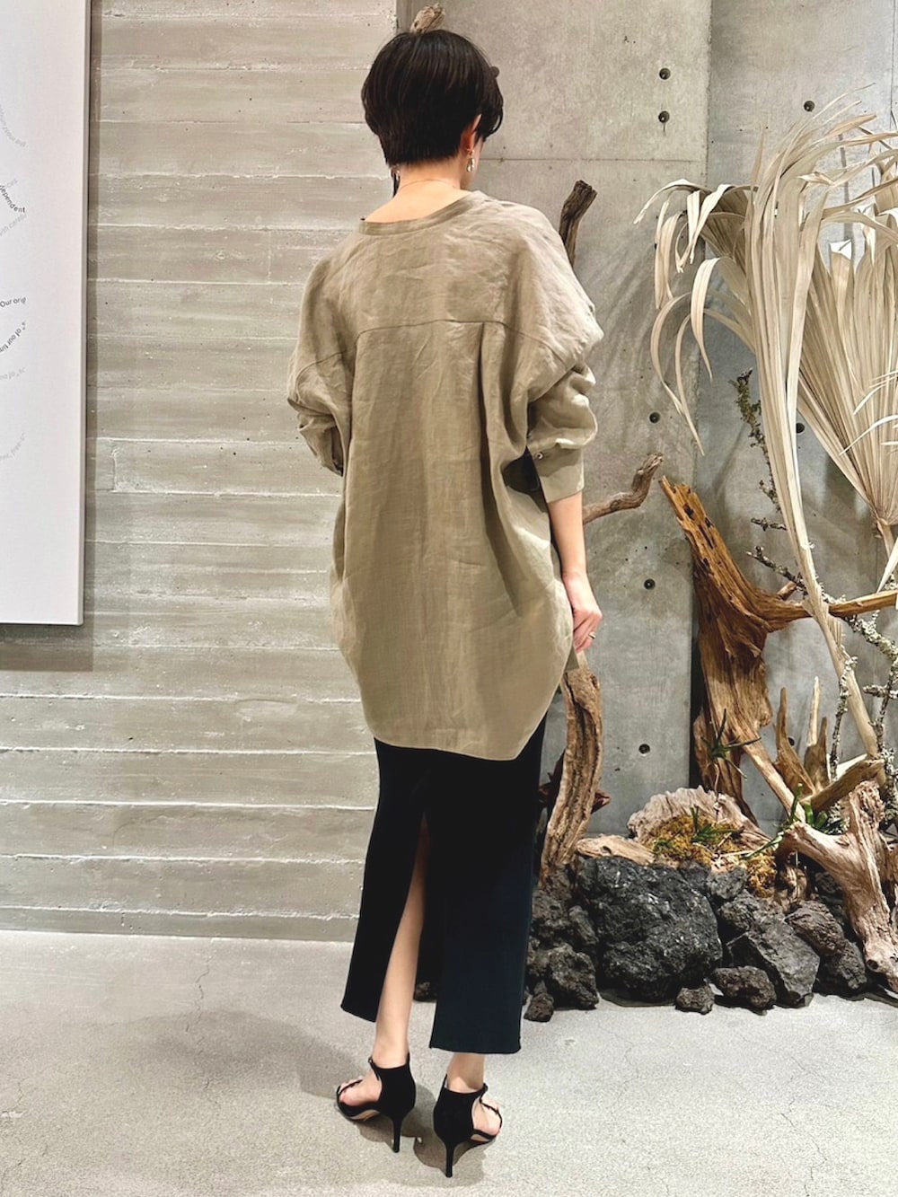 ブラック系のスカート、ブラック系のサンダル、ベージュ系のシャツ/ブラウスを着用したレディースの春コーディネートの2枚目の写真