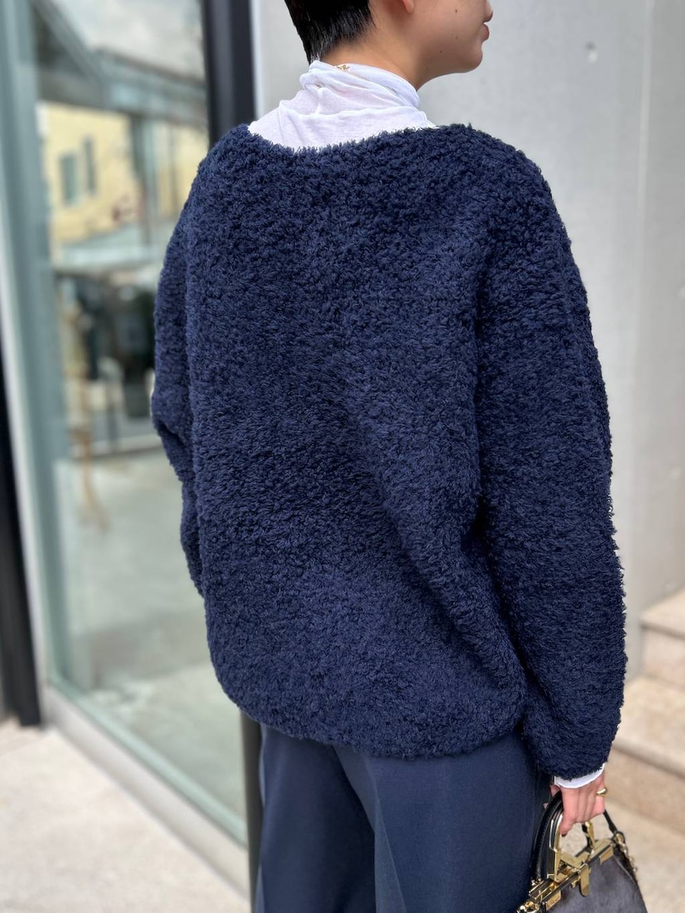 ブルー系のニット/セーター、ホワイト系のその他トップス、ブルー系のスラックスを着用したレディースの秋コーディネートの7枚目の写真