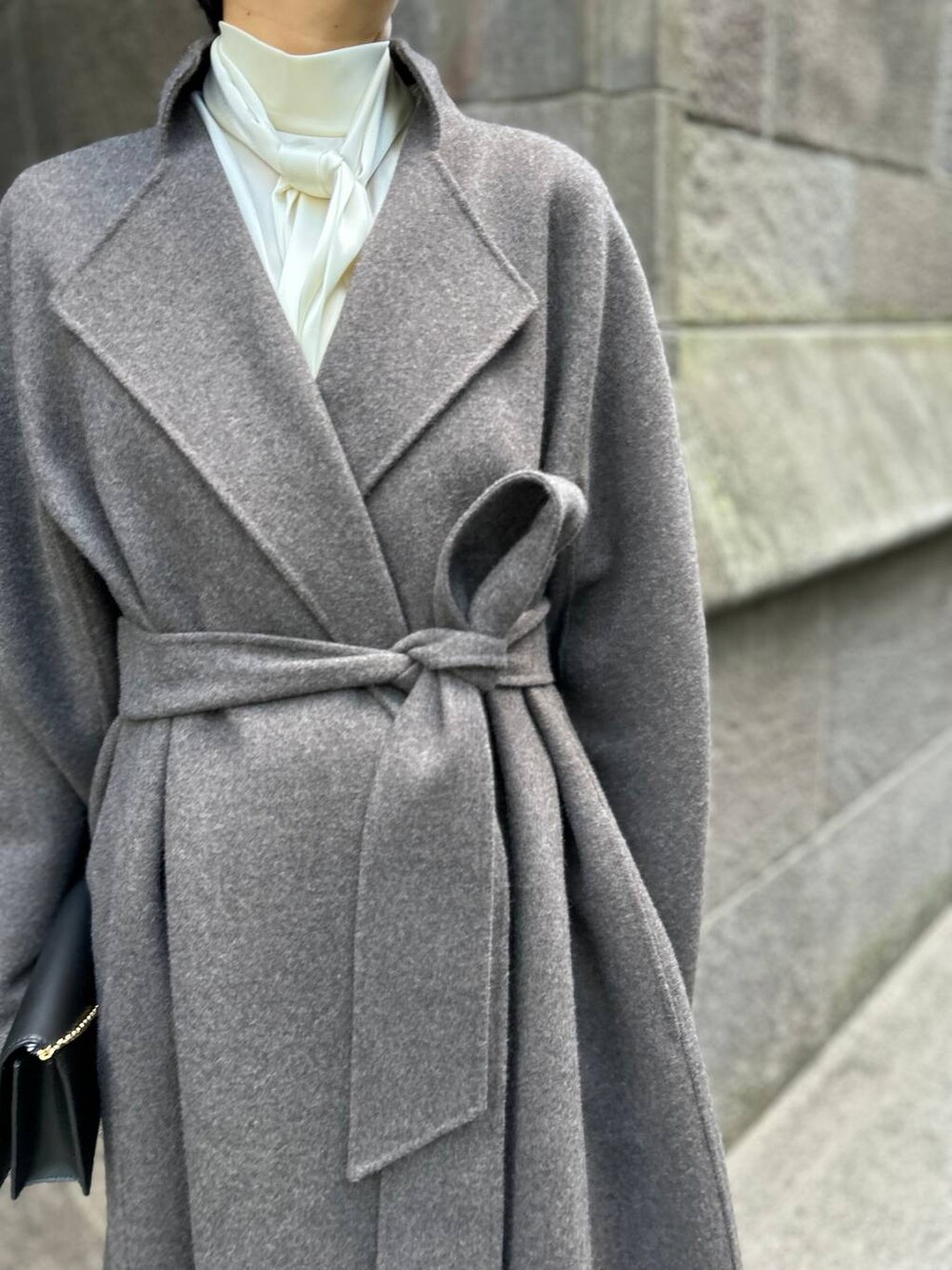 ブラウン系のノーカラーコート、ホワイト系のスラックス、ホワイト系のシャツ/ブラウスを着用したレディースの秋コーディネートの7枚目の写真