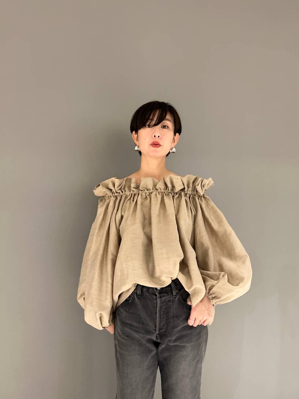 ブラック系のデニムパンツ、ベージュ系のシャツ/ブラウスを着用したレディースの冬コーディネートの3枚目の写真