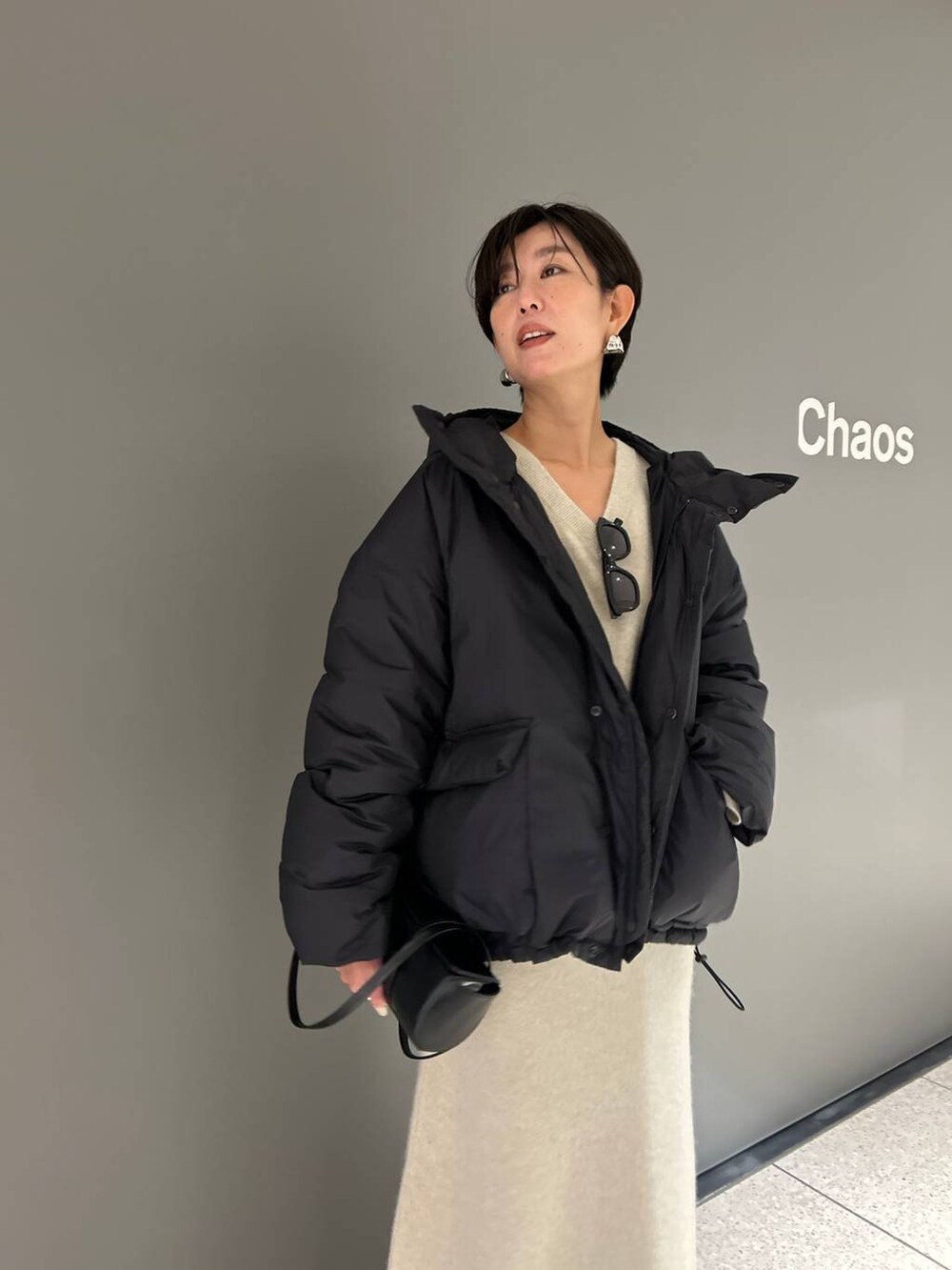 ベージュ系のニット/セーター、ベージュ系のスカート、グレー系のダウンジャケット/コートを着用したレディースの秋コーディネートの6枚目の写真