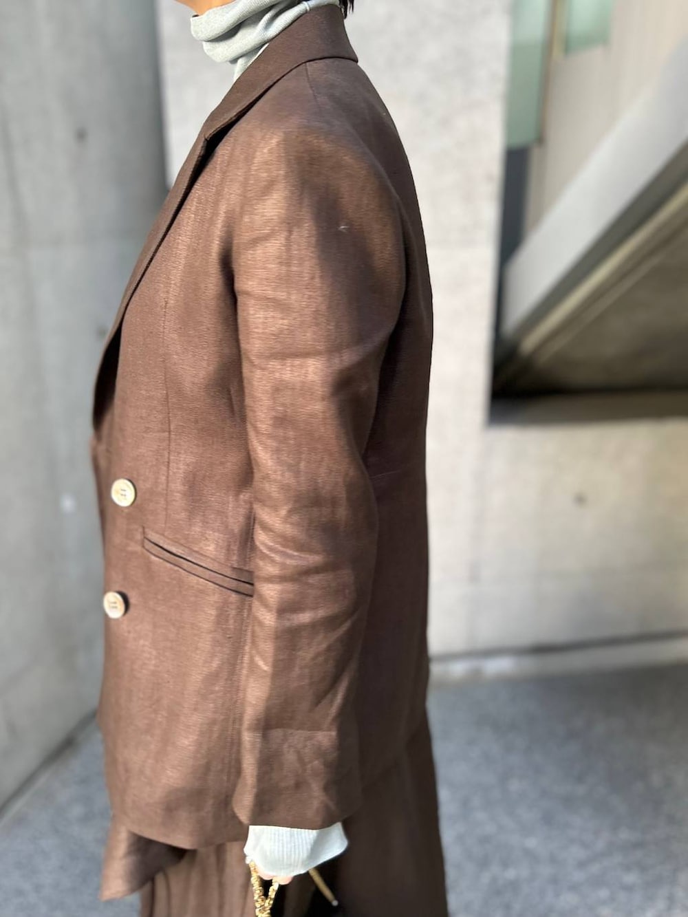 ブルー系のニット/セーター、ブラウン系のテーラードジャケット、ブラウン系のスカートを着用したレディースの冬コーディネートの7枚目の写真