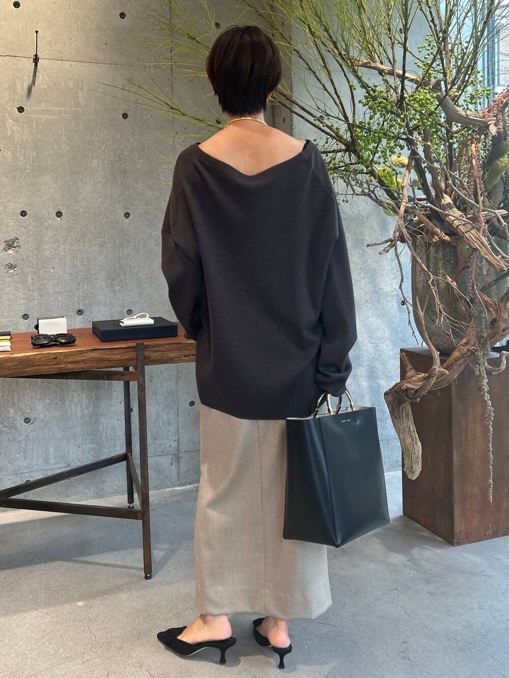 ブラウン系のニット/セーター、ベージュ系のスカート、ベージュ系のスカートを着用したレディースの秋コーディネートの3枚目の写真