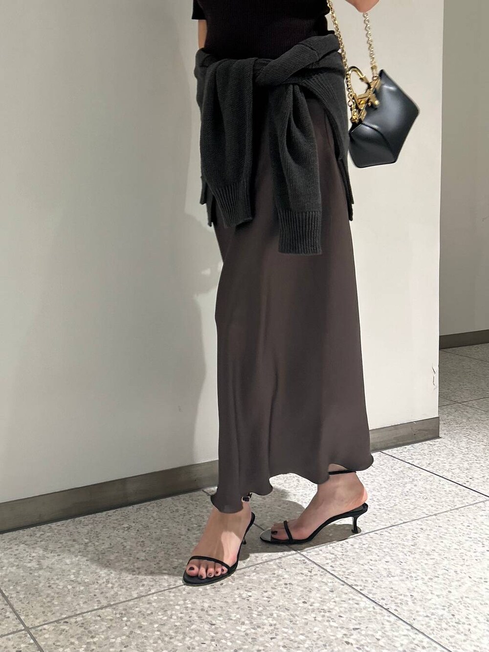 グリーン系のカーディガン/ボレロ、グリーン系のスカート、ブラウン系のTシャツ/カットソーを着用したレディースの春コーディネートの6枚目の写真