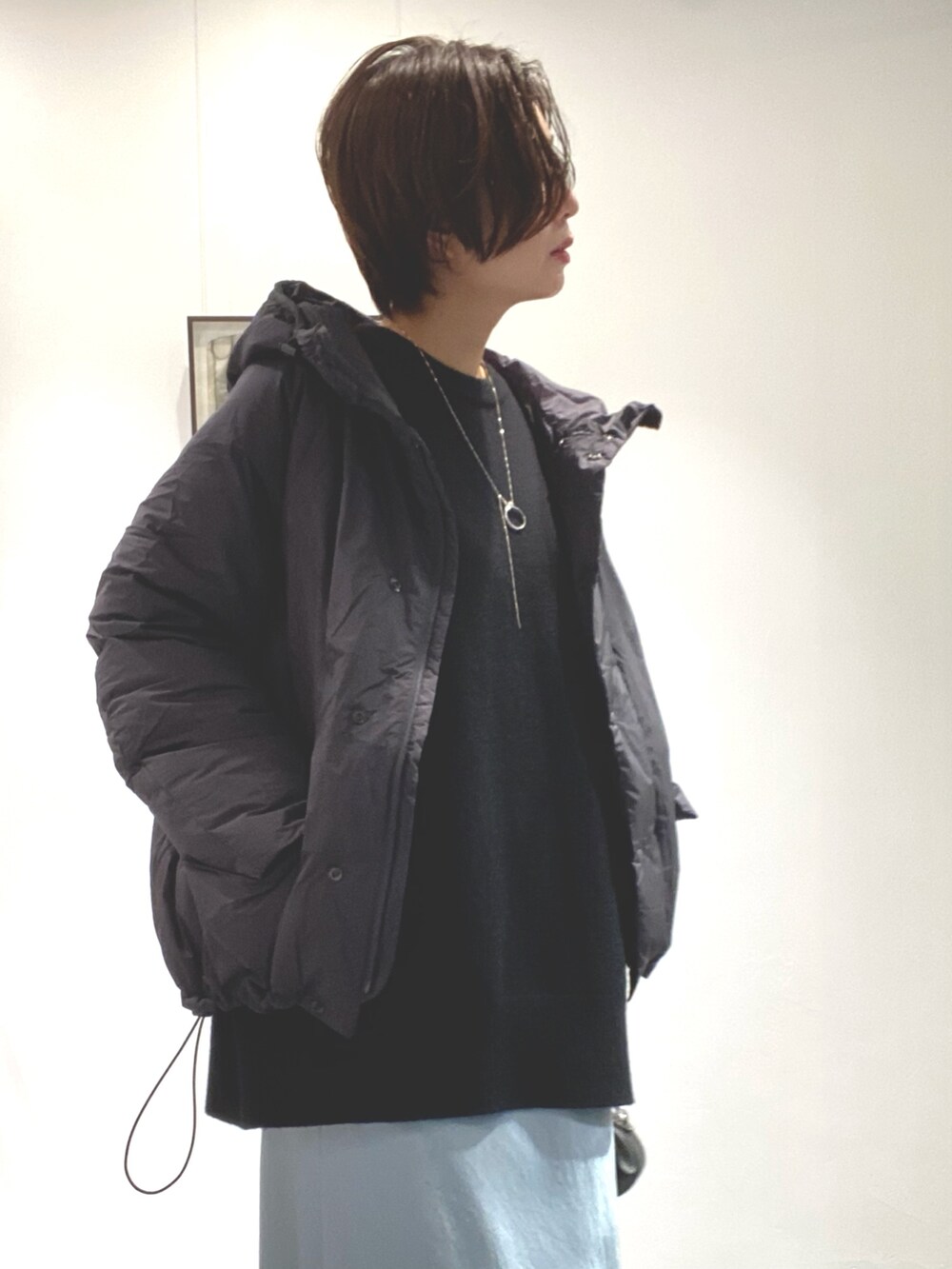 グリーン系のスカート、ブラック系のニット/セーター、グレー系のジャケット/アウターを着用したレディースの秋コーディネートの5枚目の写真