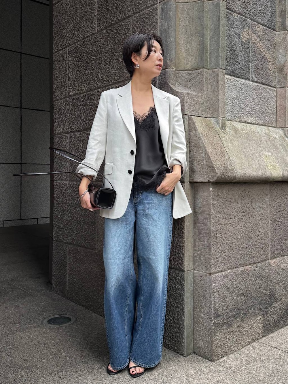 ブルー系のデニムパンツ、ホワイト系のテーラードジャケットを着用したレディースの冬コーディネートの2枚目の写真