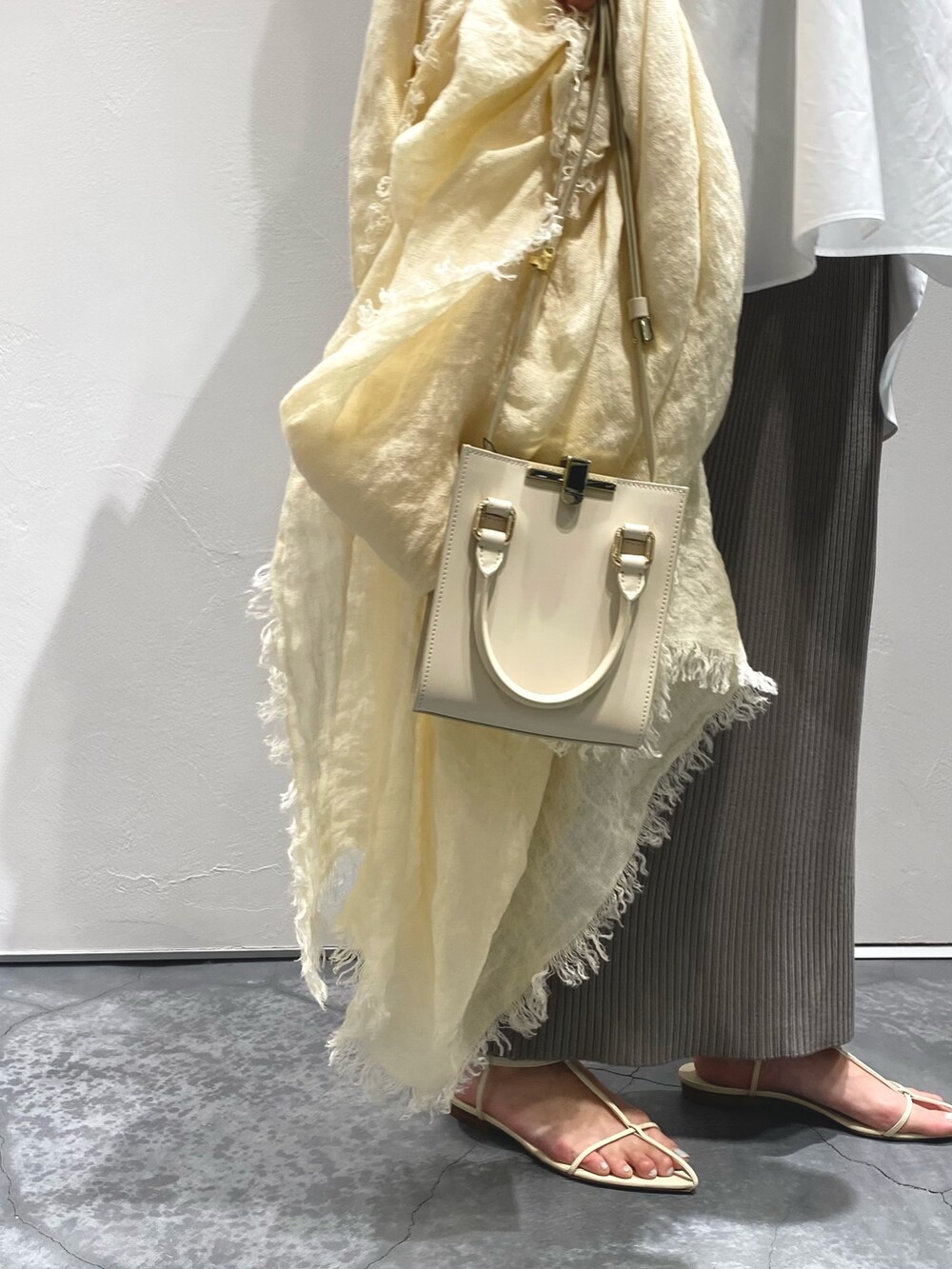 ホワイト系のシャツ/ブラウス、グレー系のスカート、ホワイト系のシューズを着用したレディースの春コーディネートの3枚目の写真
