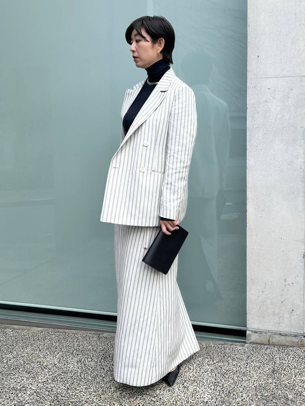 ブルー系のニット/セーター、ホワイト系のテーラードジャケット、ホワイト系のスカートを着用したレディースの冬コーディネートの4枚目の写真