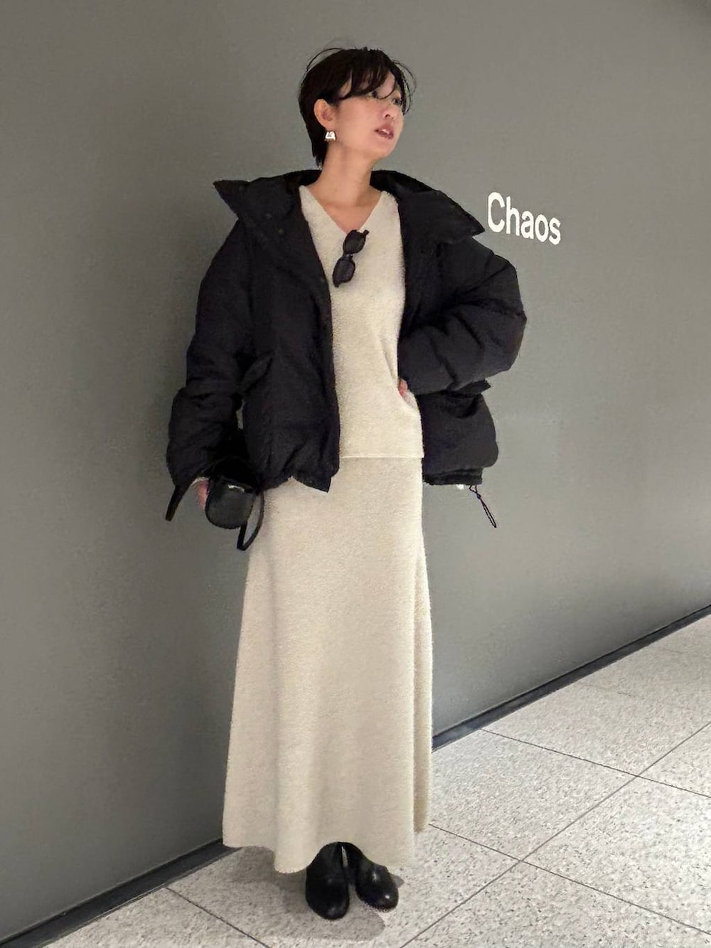 ベージュ系のニット/セーター、ベージュ系のスカート、グレー系のダウンジャケット/コートを着用したレディースの秋コーディネートの2枚目の写真