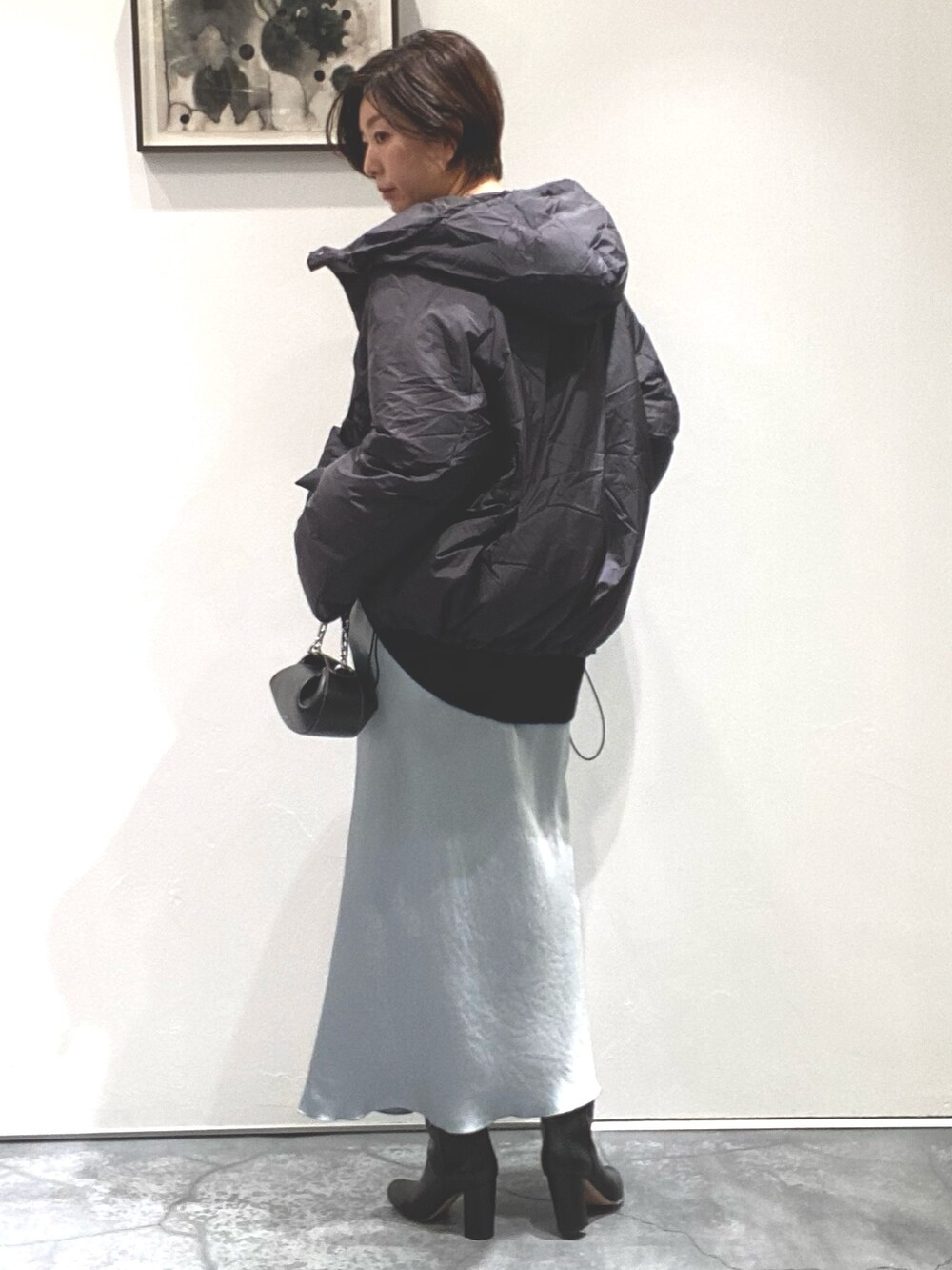 グリーン系のスカート、ブラック系のニット/セーター、グレー系のジャケット/アウターを着用したレディースの秋コーディネートの3枚目の写真