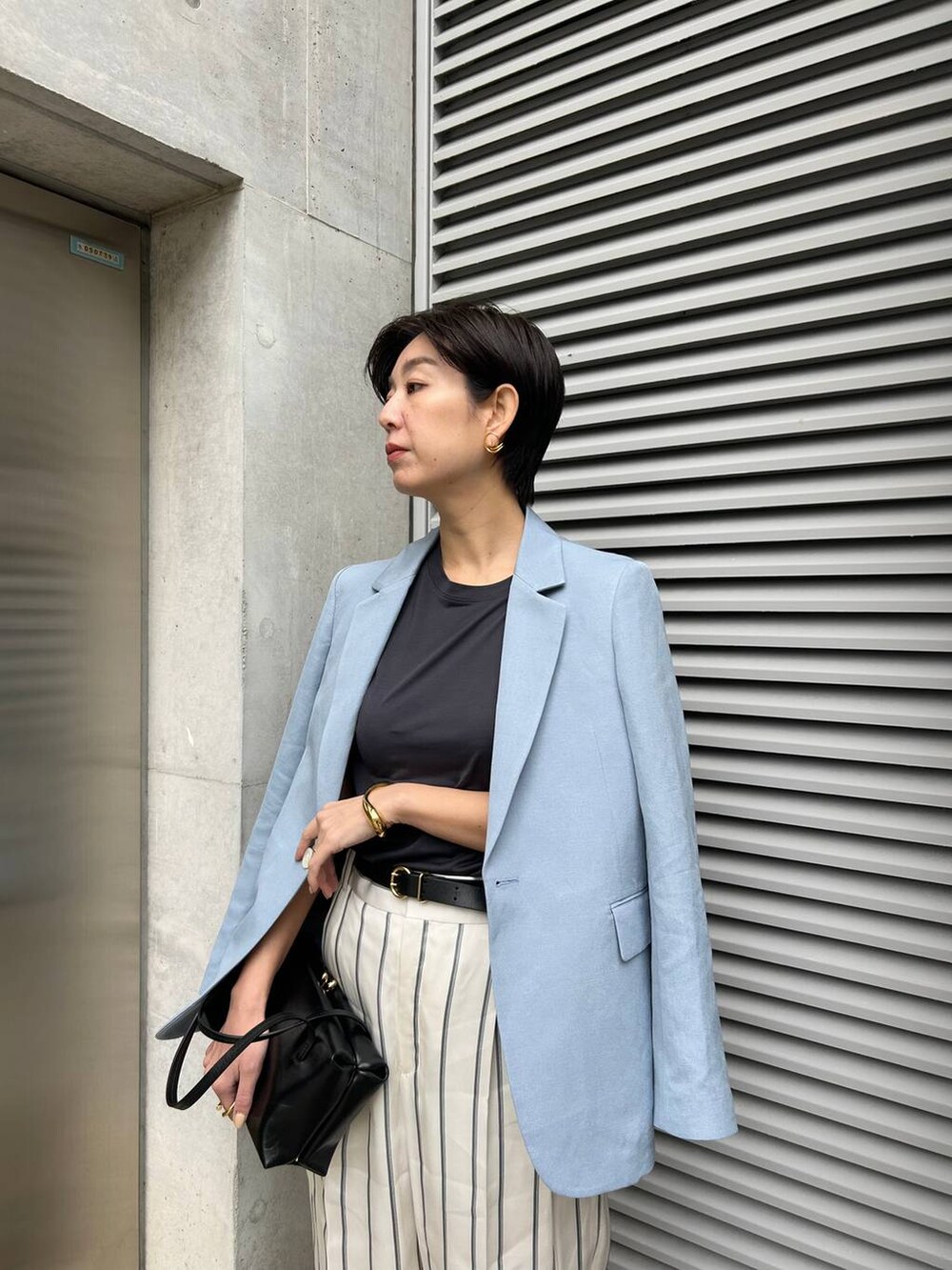 ホワイト系のスラックス、ブルー系のTシャツ/カットソー、ブルー系のテーラードジャケットを着用したレディースの春コーディネートの5枚目の写真