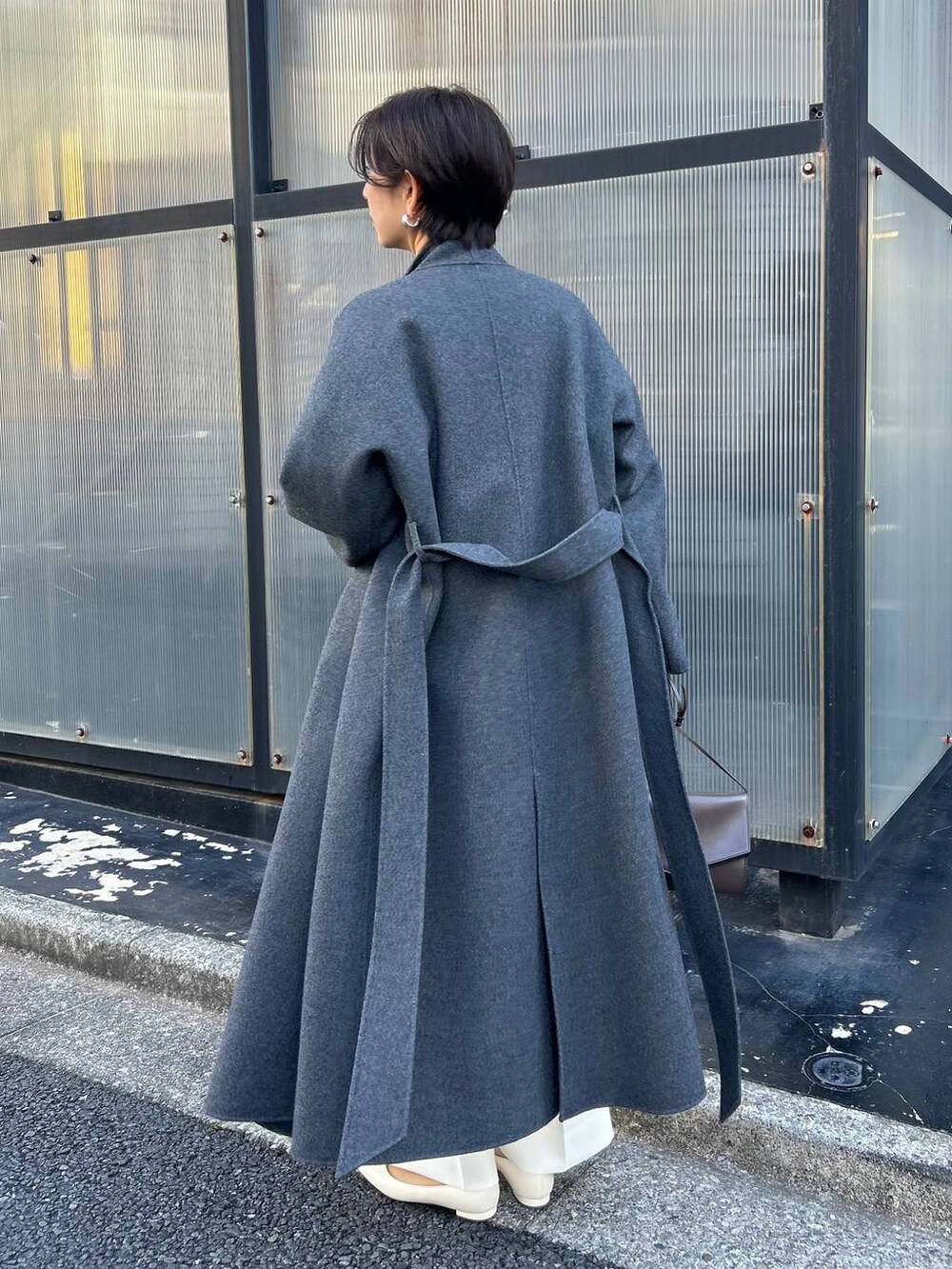 ブルー系のカーディガン/ボレロ、グレー系のノーカラーコート、ホワイト系のスラックスを着用したレディースの冬コーディネートの4枚目の写真