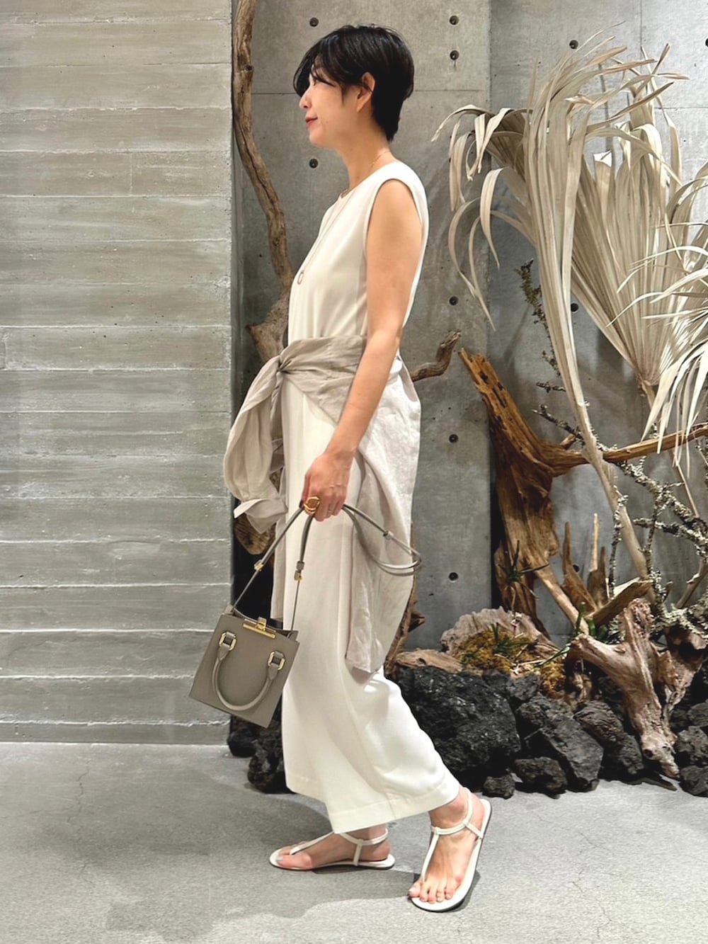 ベージュ系のシャツ/ブラウス、ベージュ系のサロペット/オーバーオール、ベージュ系のバッグを着用したレディースの春コーディネートの3枚目の写真