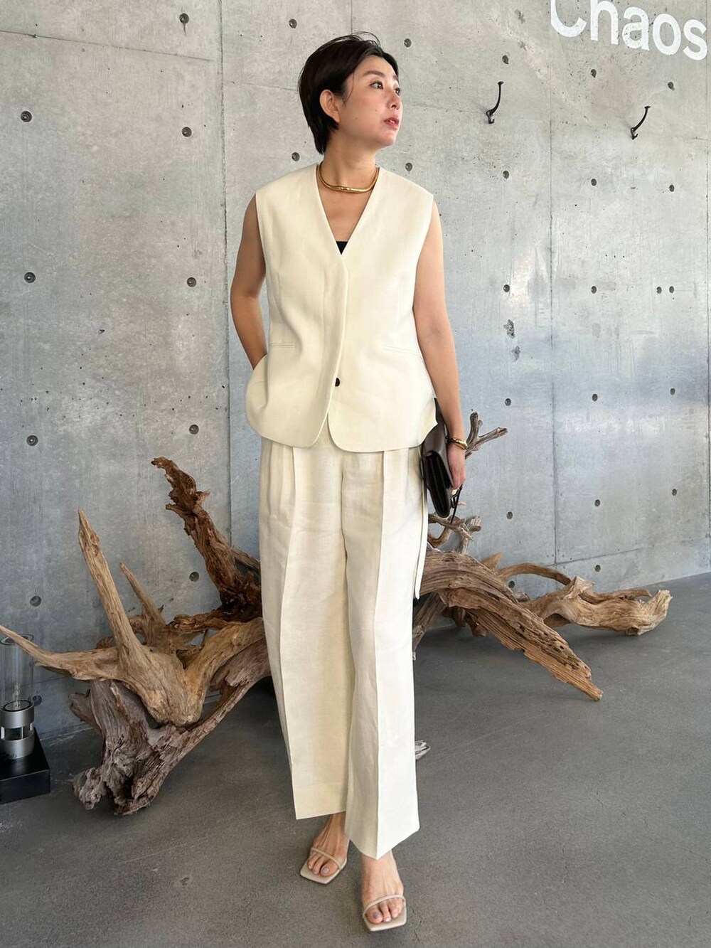 ブルー系のキャミソール、ベージュ系のサンダル、ホワイト系のスラックスを着用したレディースの夏コーディネートの2枚目の写真