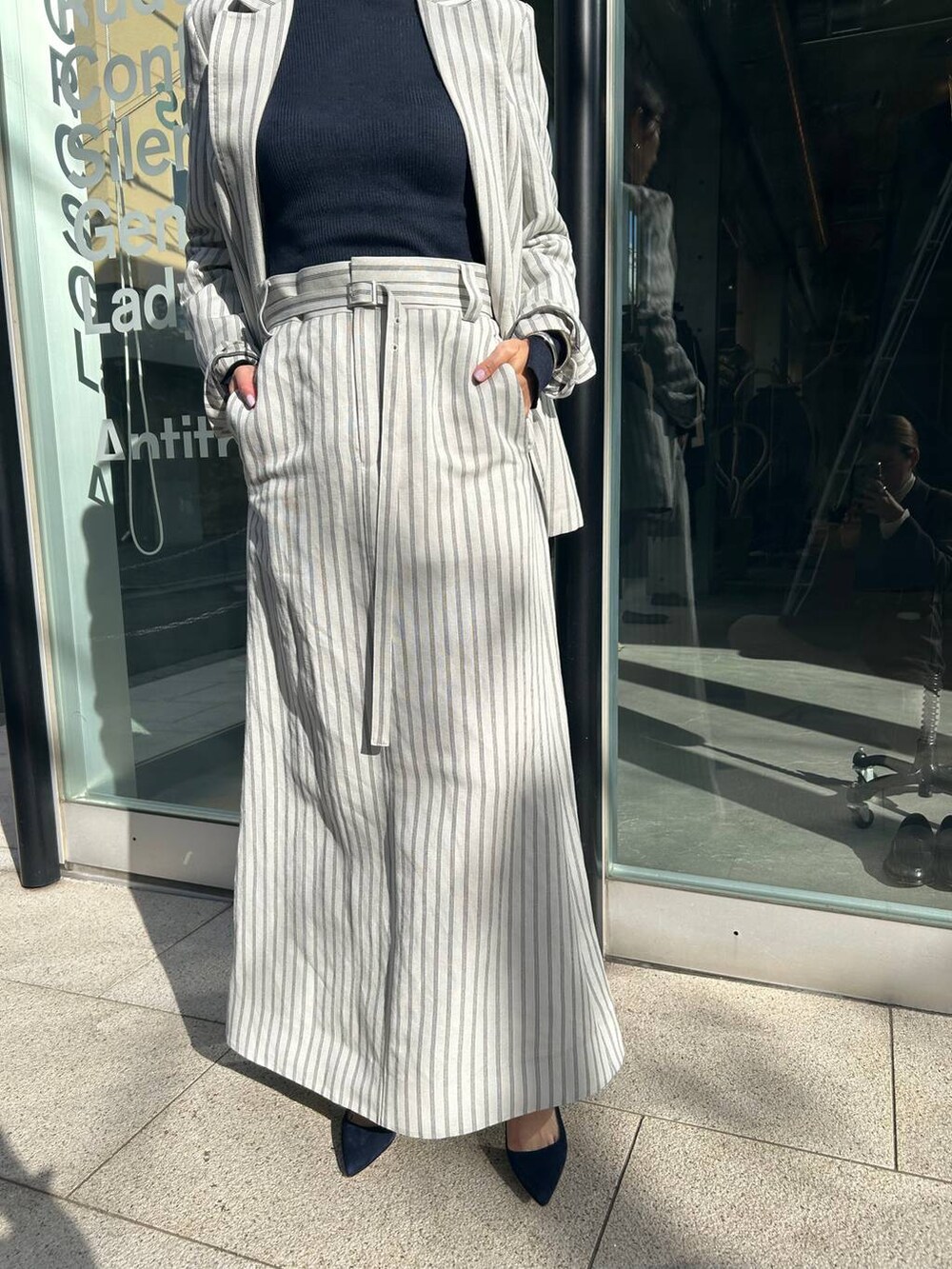 ブルー系のニット/セーター、ホワイト系のテーラードジャケット、ホワイト系のスカートを着用したレディースの冬コーディネートの7枚目の写真