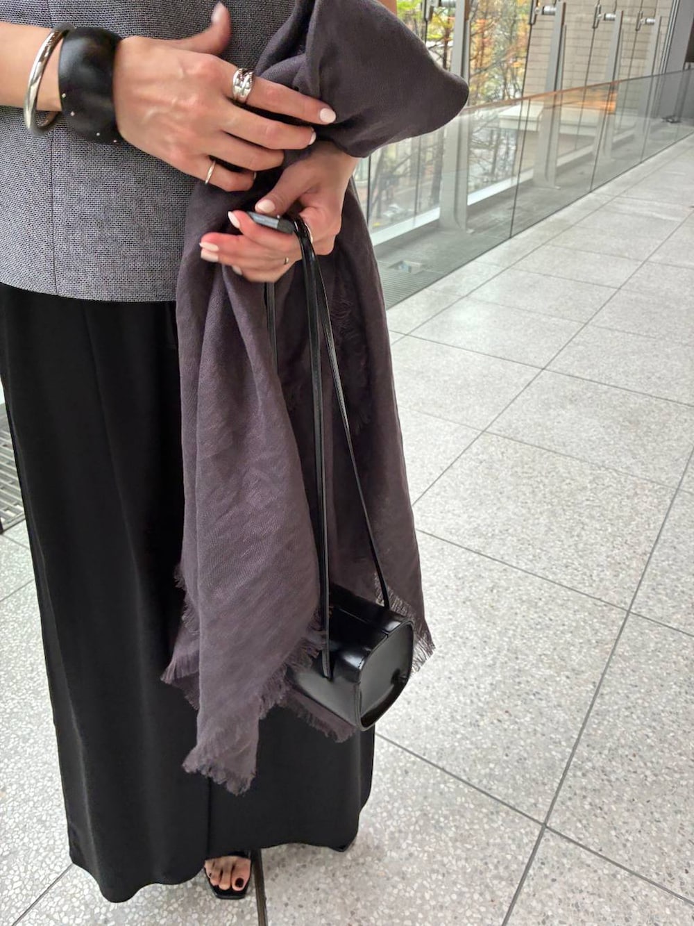 ブラック系のその他パンツ、ホワイト系のその他トップス、ブラウン系のストール/ショールを着用したレディースの春コーディネートの8枚目の写真