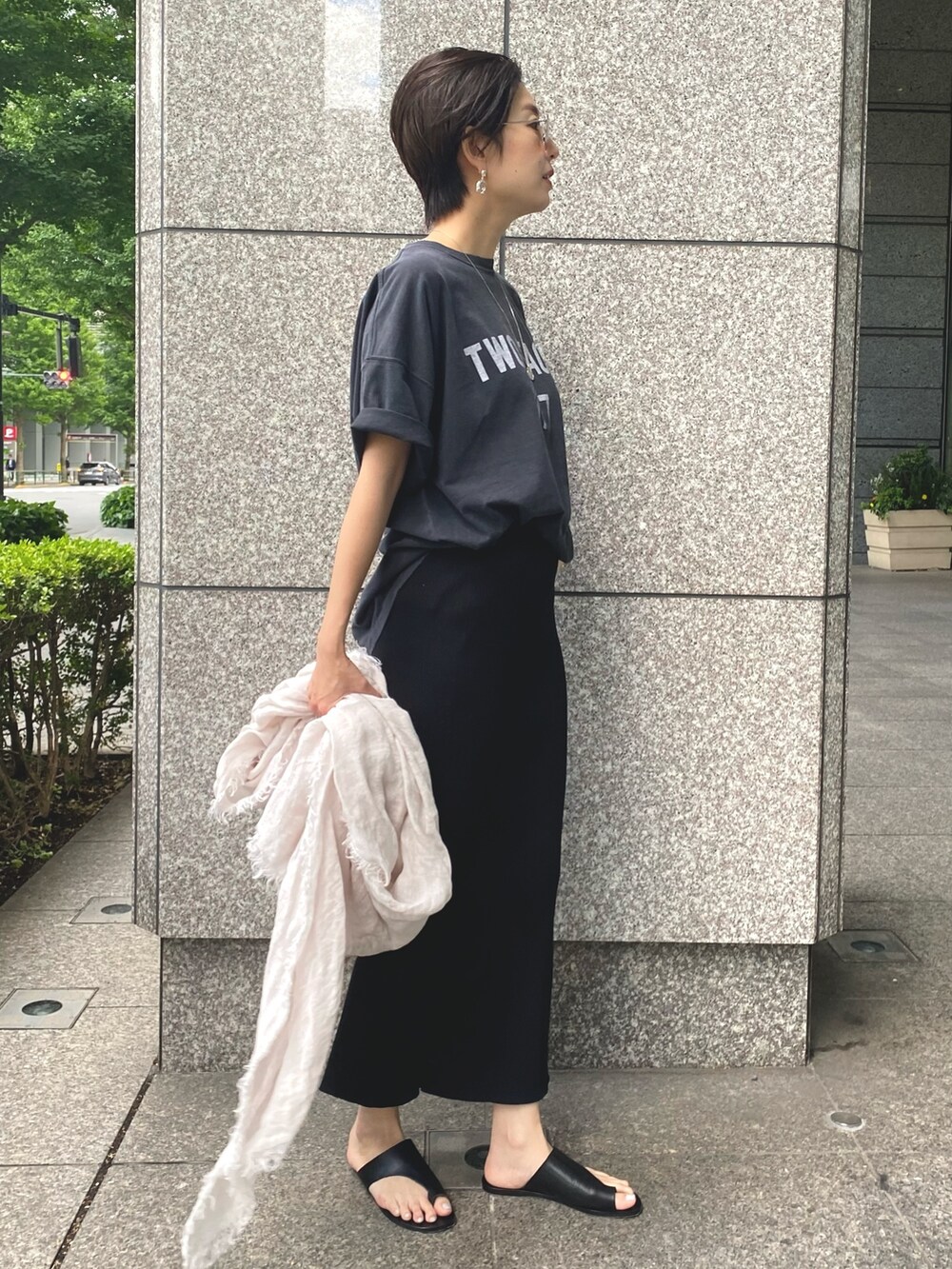 ブラック系のTシャツ/カットソー、ブラック系のスカート、ベージュ系のストール/ショールを着用したレディースの春コーディネートの2枚目の写真