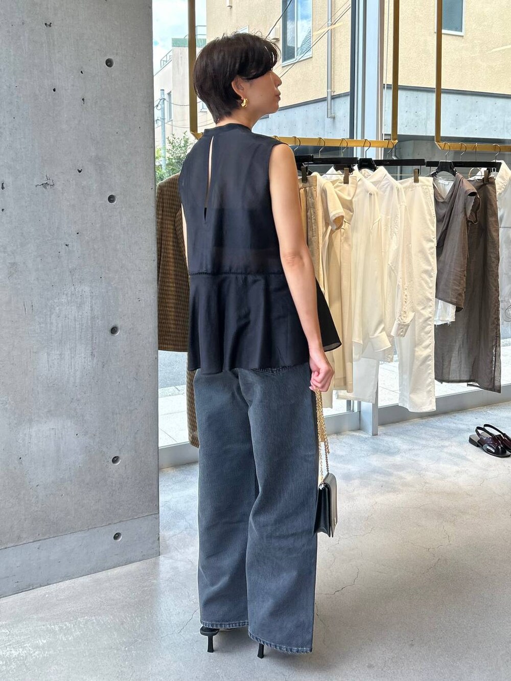 ブラック系のキャミソール、ブラック系のサンダル、ブラック系のデニムパンツを着用したレディースの夏コーディネートの4枚目の写真