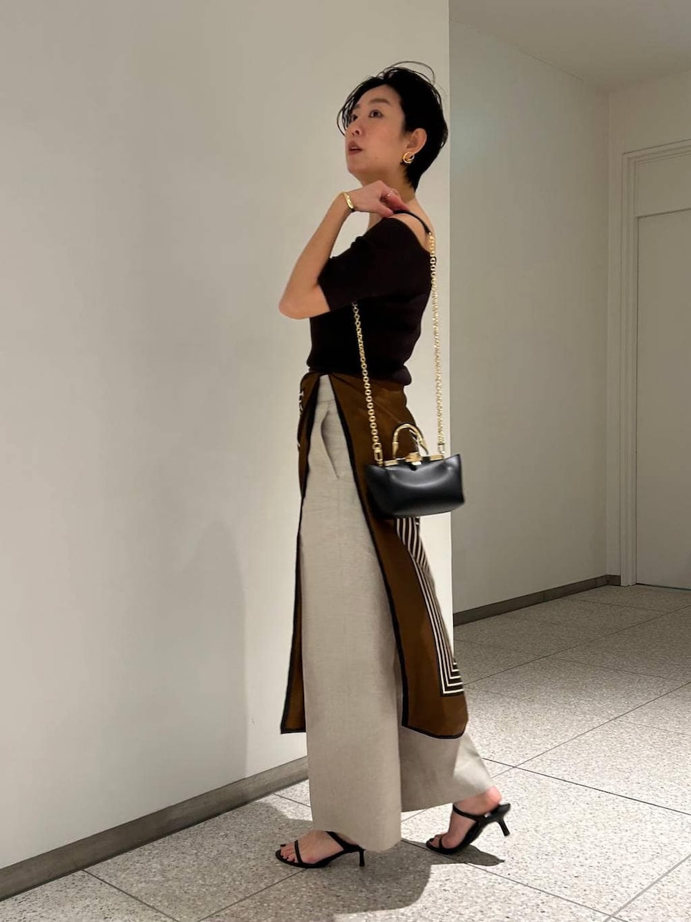 ホワイト系のスラックス、ブラウン系のTシャツ/カットソー、ブラウン系のバンダナ/スカーフを着用したレディースの春コーディネートの4枚目の写真