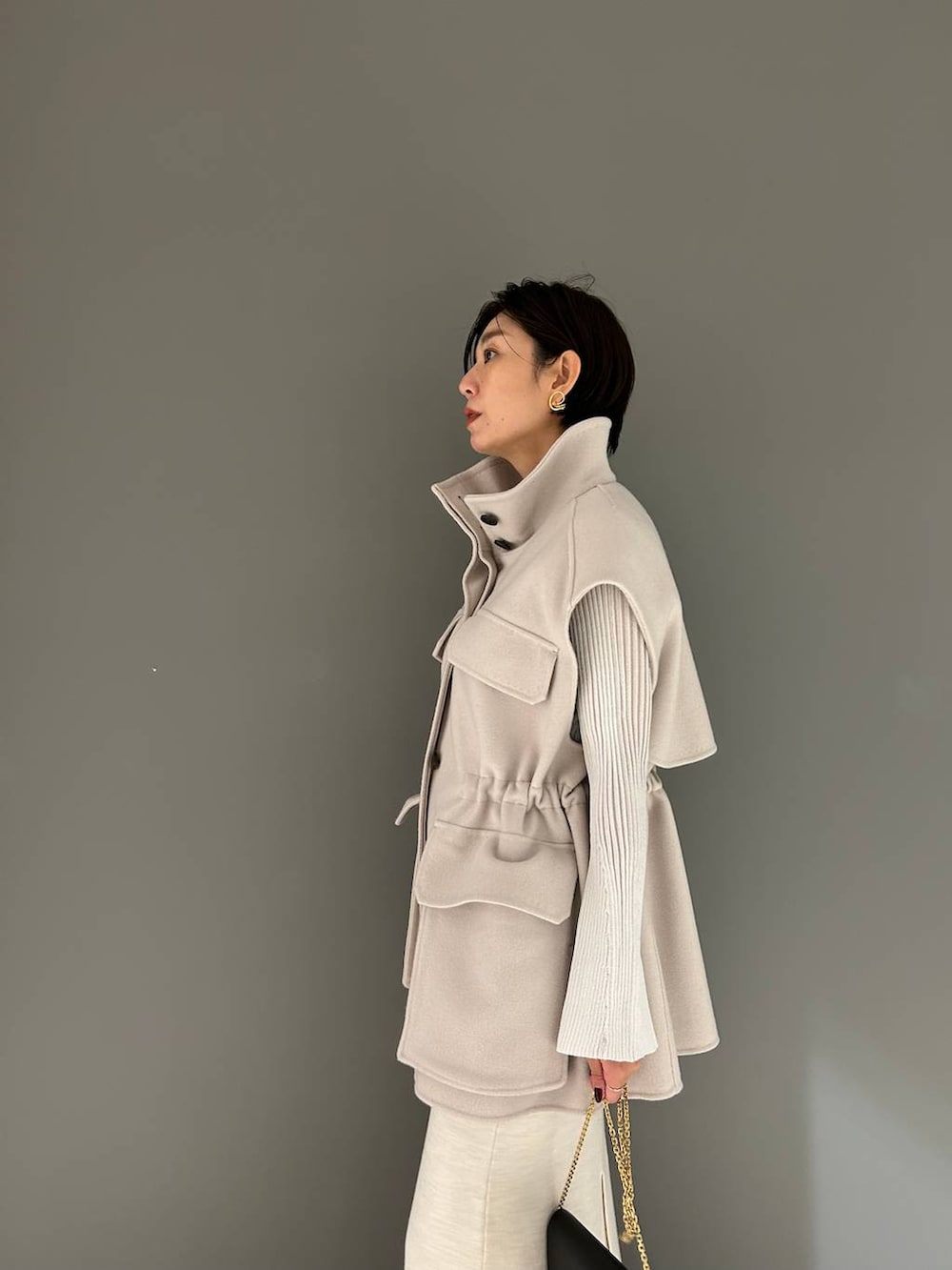 ホワイト系のその他アウター、ホワイト系のニット/セーター、ホワイト系のスカートを着用したレディースの秋コーディネートの6枚目の写真