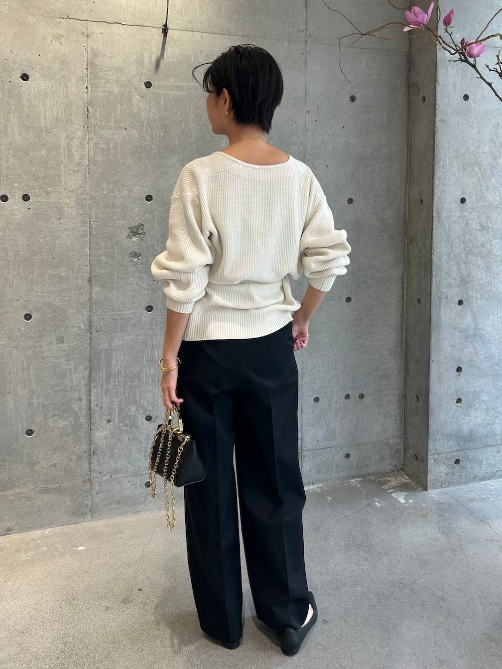 ブラック系のその他トップス、ホワイト系のカーディガン/ボレロ、ブラック系のスラックスを着用したレディースの冬コーディネートの2枚目の写真