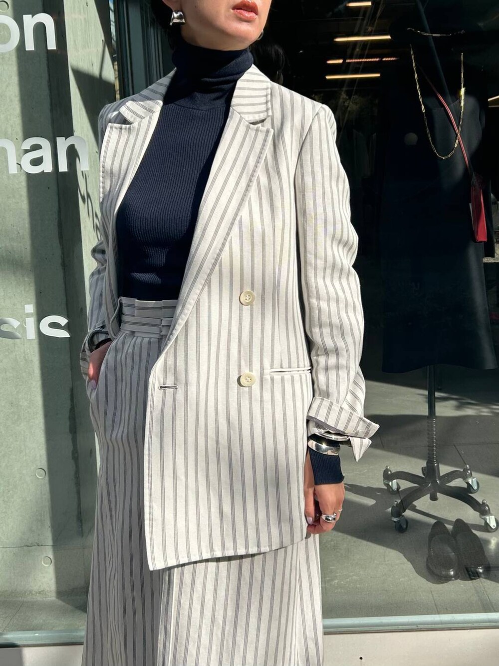 ブルー系のニット/セーター、ホワイト系のテーラードジャケット、ホワイト系のスカートを着用したレディースの冬コーディネートの6枚目の写真