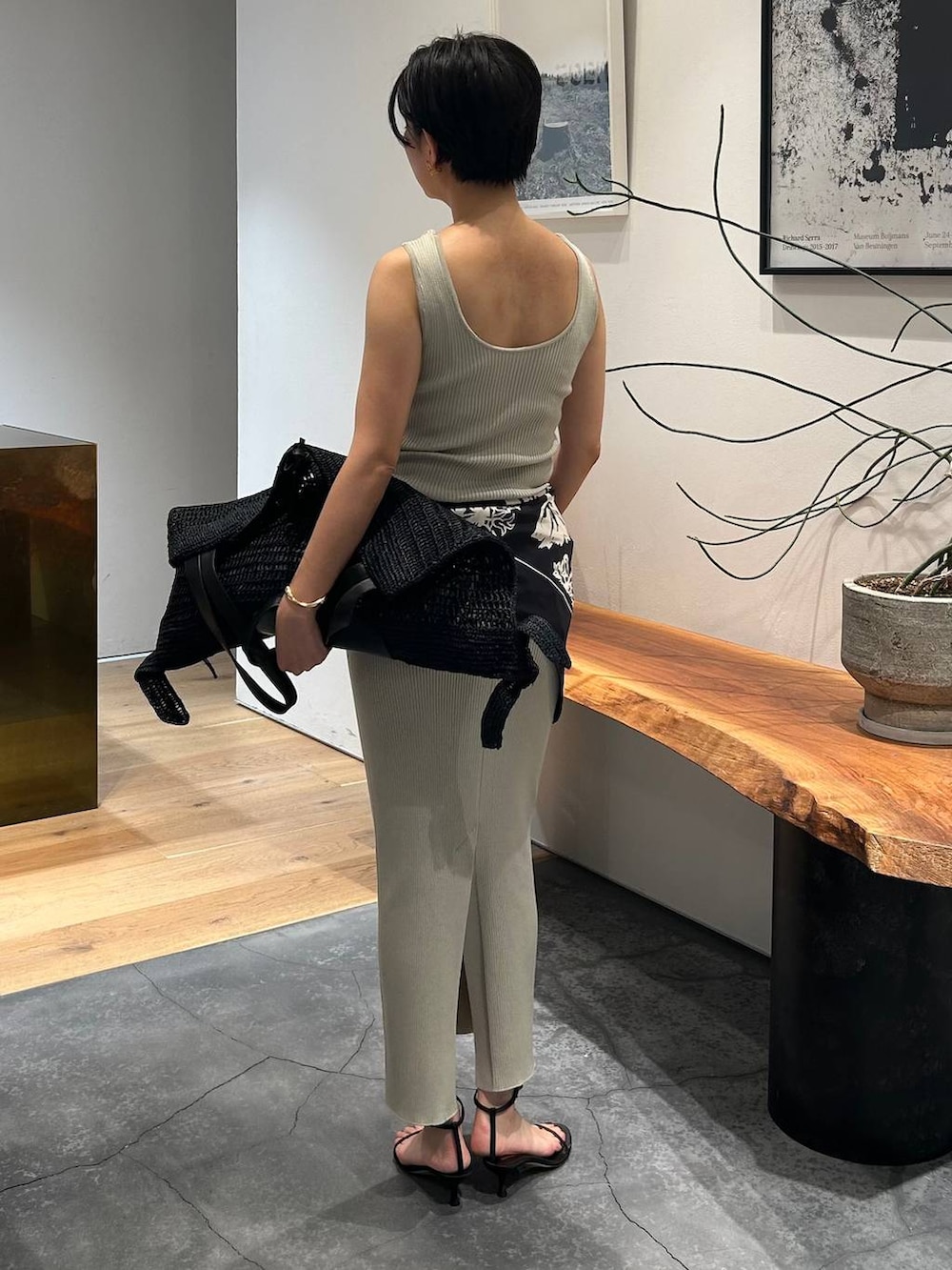 グレー系のタンクトップ、ブラック系のブルゾン、グレー系のスカートを着用したレディースの春コーディネートの5枚目の写真