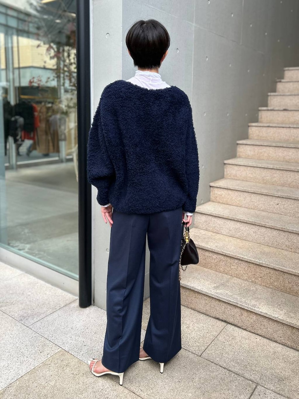 ブルー系のニット/セーター、ホワイト系のその他トップス、ブルー系のスラックスを着用したレディースの秋コーディネートの5枚目の写真