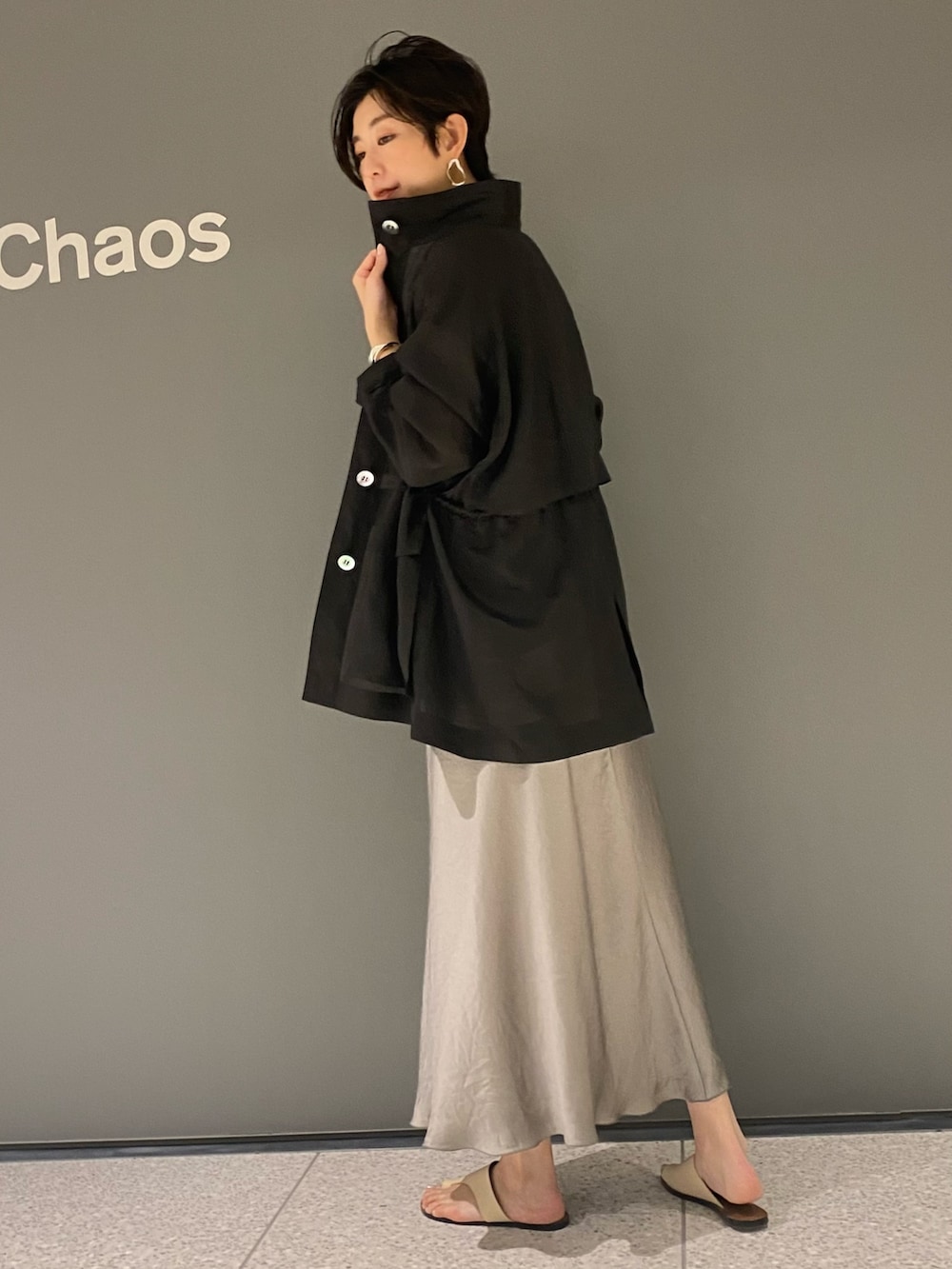 グリーン系のスカート、ブラック系のタンクトップ、ブラック系のジャケット/アウターを着用したレディースの春コーディネートの3枚目の写真